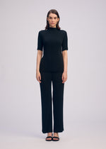 A model wears the ISSEY MIYAKE HATCHING PLEATS shirt.