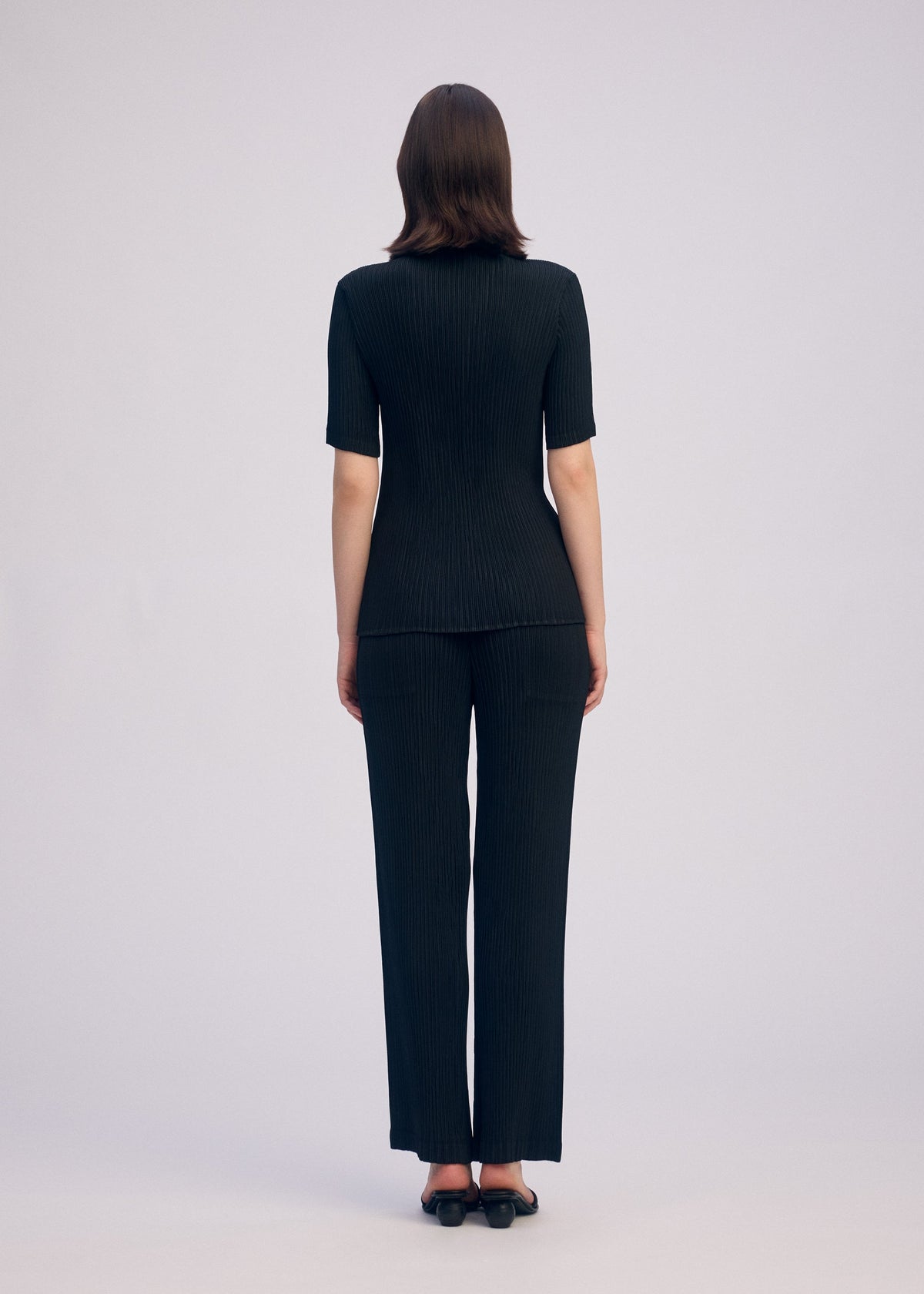 A model wears the ISSEY MIYAKE HATCHING PLEATS shirt.