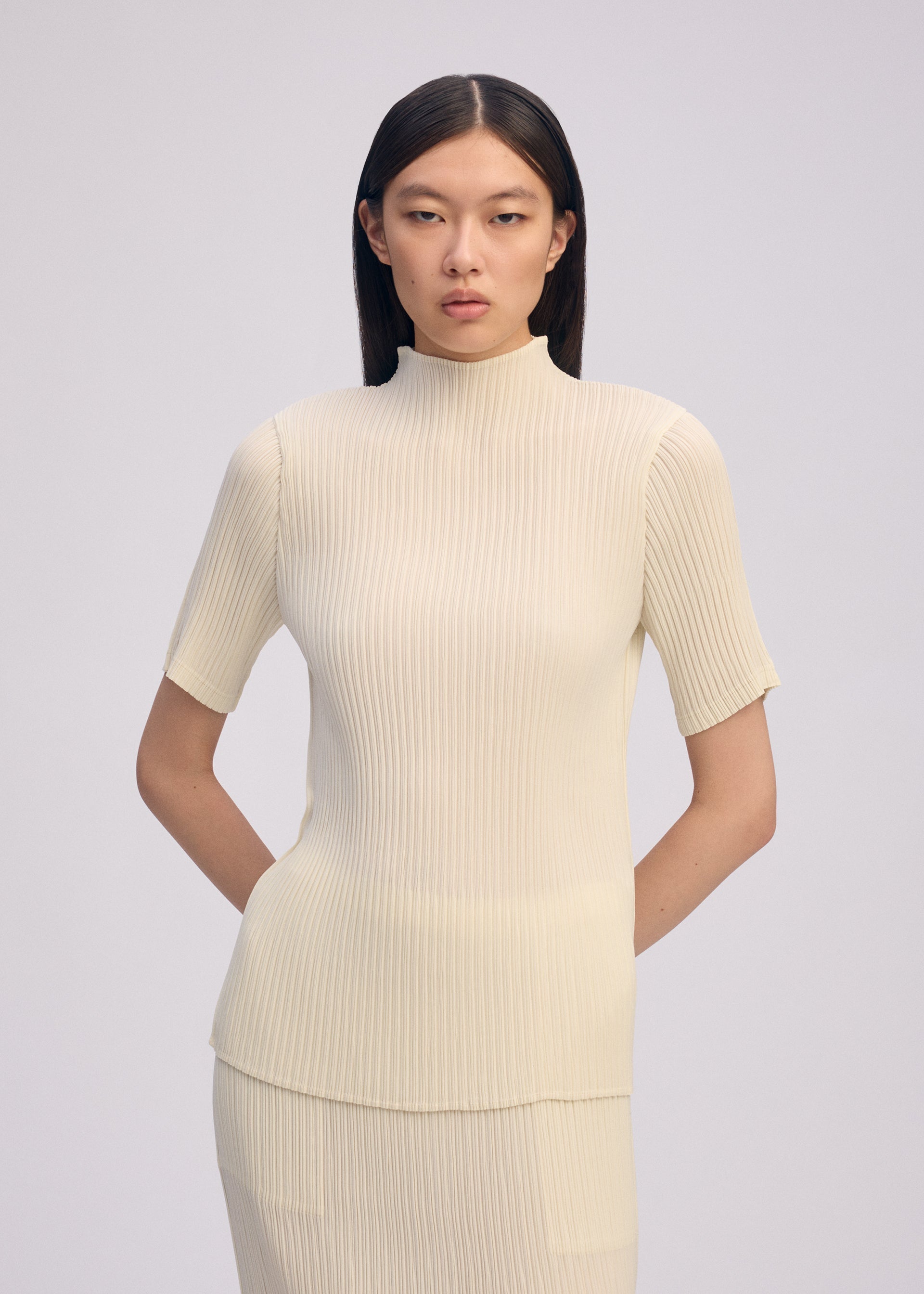 A model wears the ISSEY MIYAKE HATCHING PLEATS shirt.