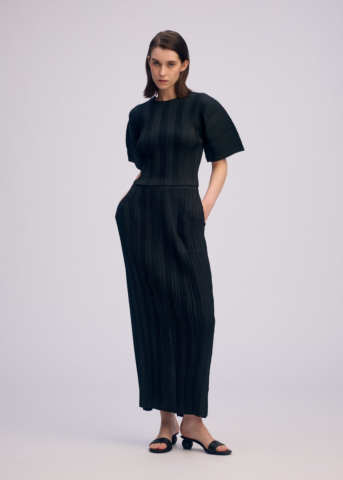 A model wears the ISSEY MIYAKE LINEN LIKE RIB PLEATS shirt.