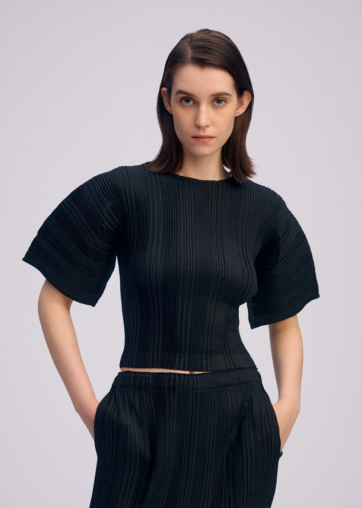 A model wears the ISSEY MIYAKE LINEN LIKE RIB PLEATS shirt.