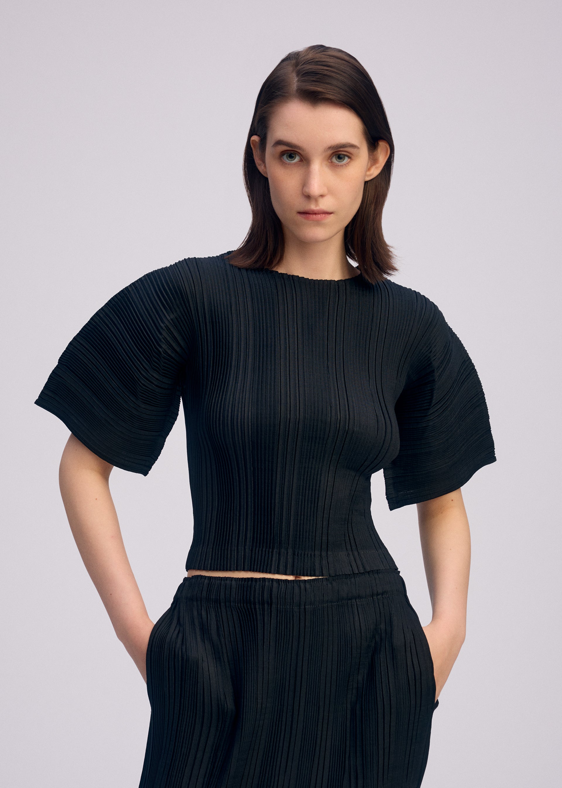 A model wears the ISSEY MIYAKE LINEN LIKE RIB PLEATS shirt.