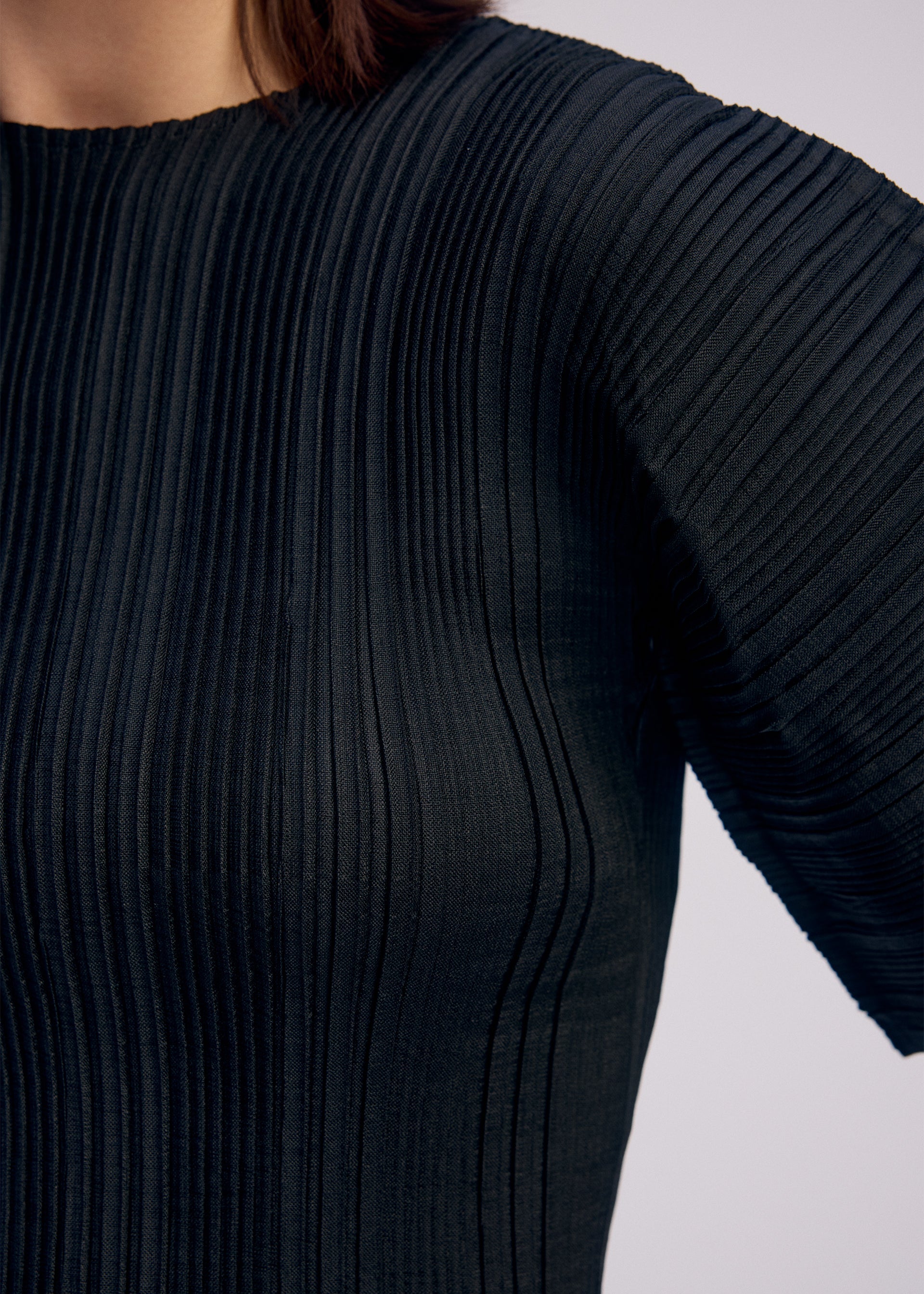 A model wears the ISSEY MIYAKE LINEN LIKE RIB PLEATS shirt.