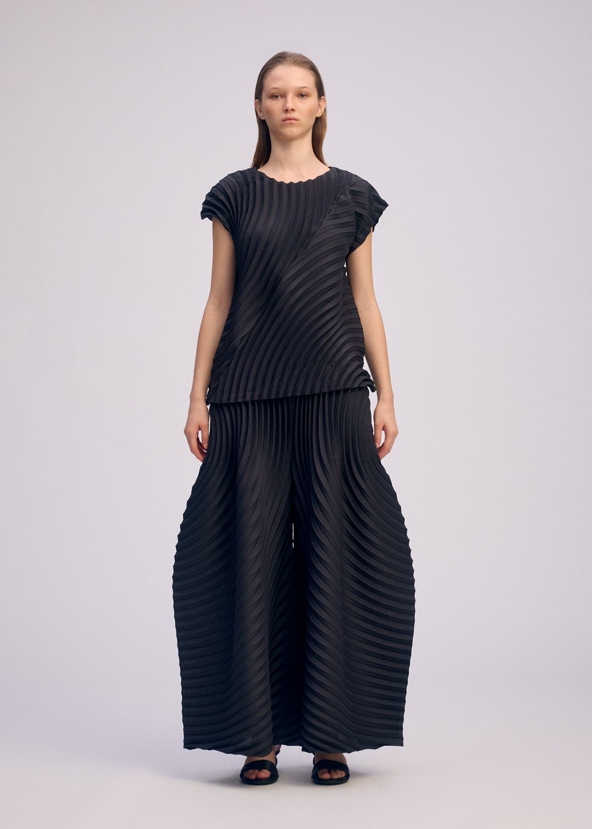 A model wears the ISSEY MIYAKE CIRCLE PLEATS PB shirt.