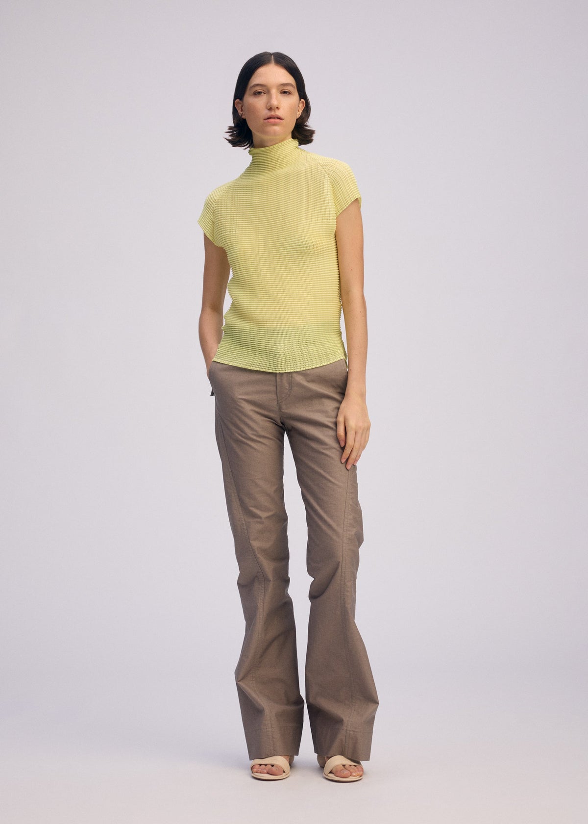 A model wears the ISSEY MIYAKE WOOLY PLEATS 66 clothing.