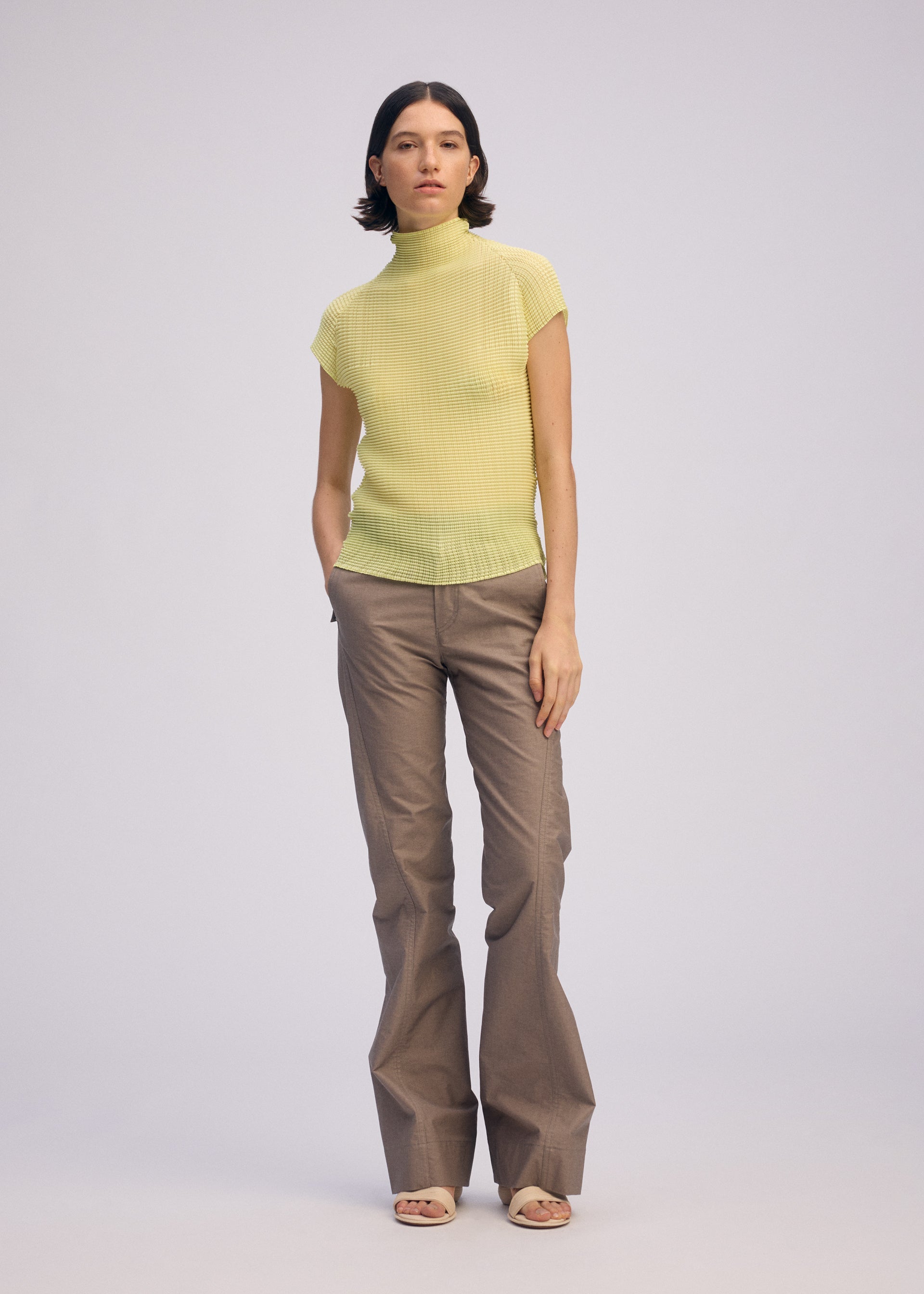 A model wears the ISSEY MIYAKE WOOLY PLEATS 66 clothing.