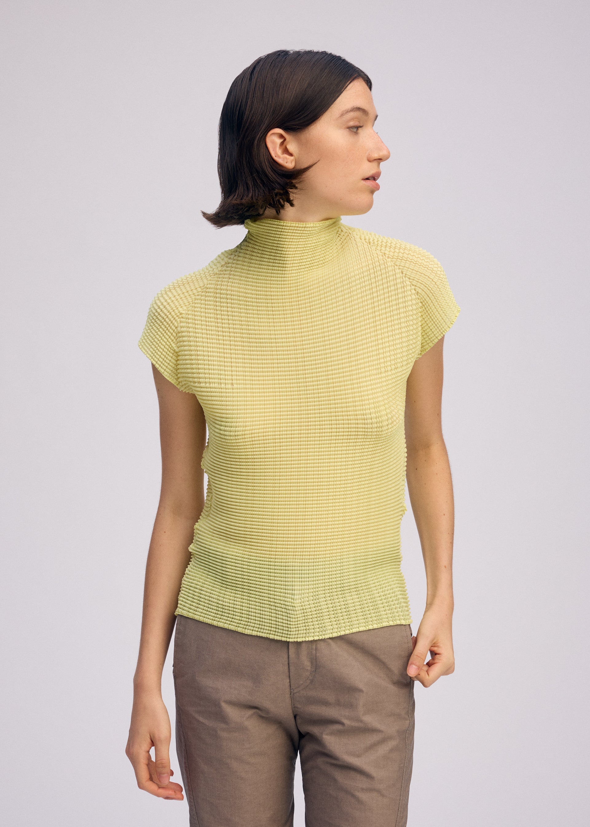 A model wears the ISSEY MIYAKE WOOLY PLEATS 66 clothing.