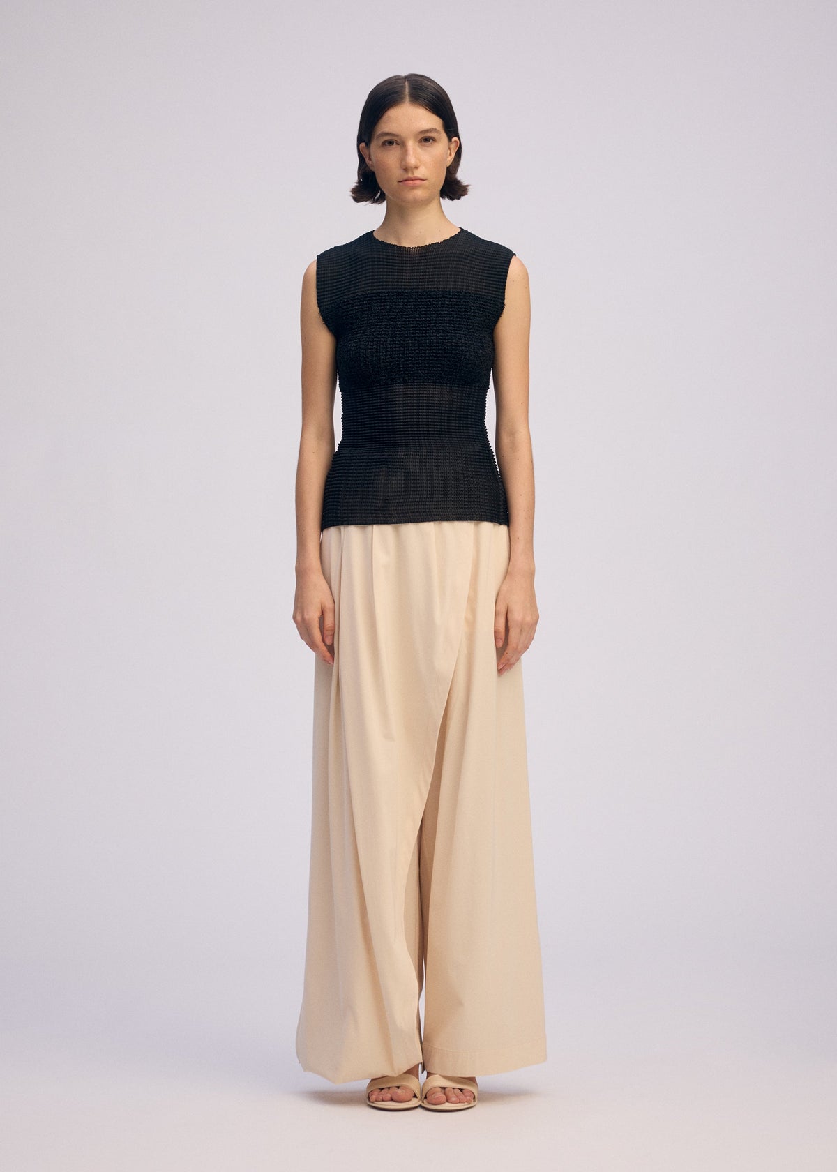 A model wears the ISSEY MIYAKE SHEER FUZZY PLEATS shirt.