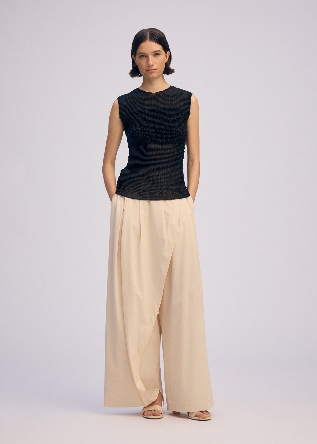 A model wears the ISSEY MIYAKE SHEER FUZZY PLEATS shirt.
