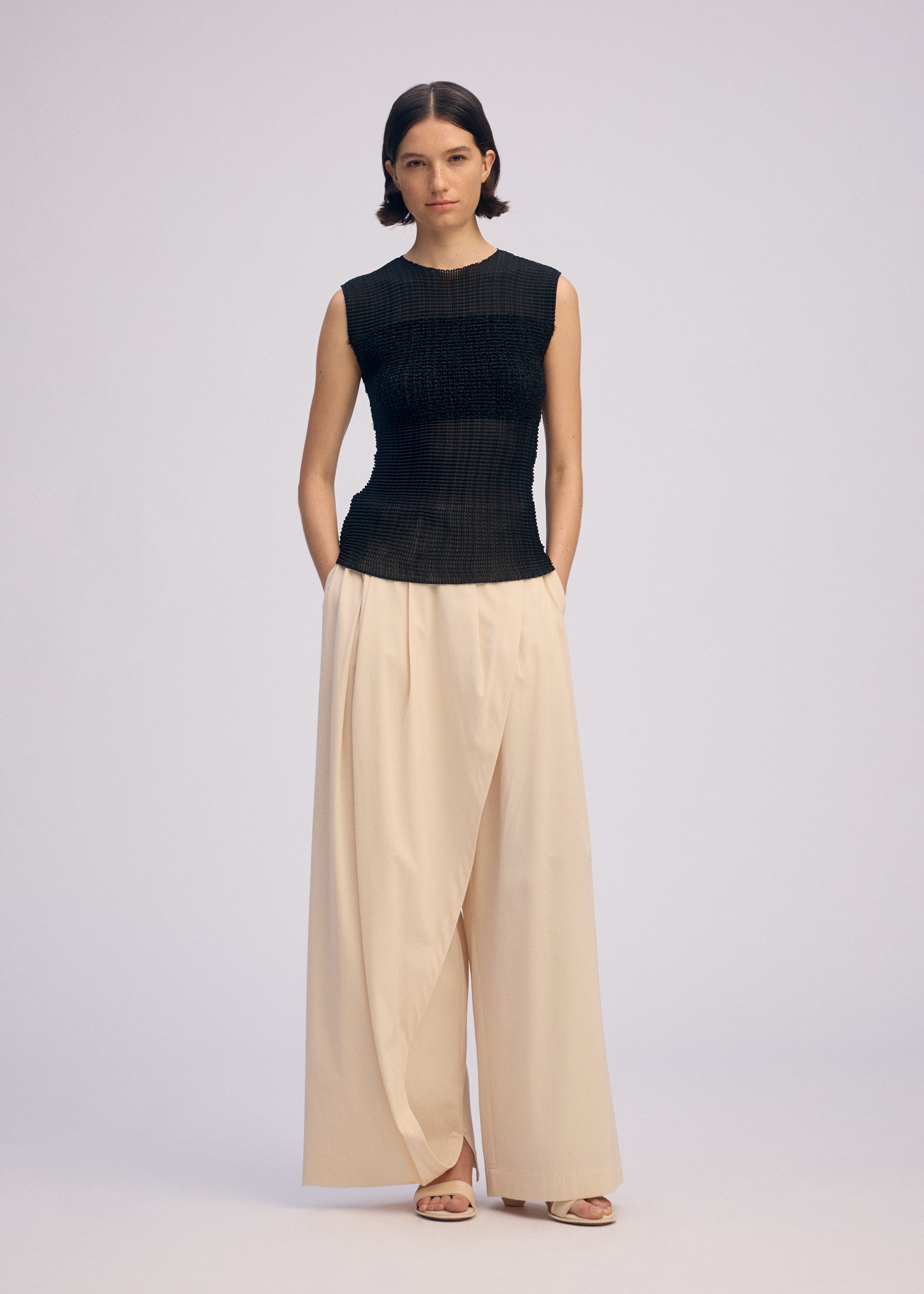 A model wears the ISSEY MIYAKE SHEER FUZZY PLEATS shirt.