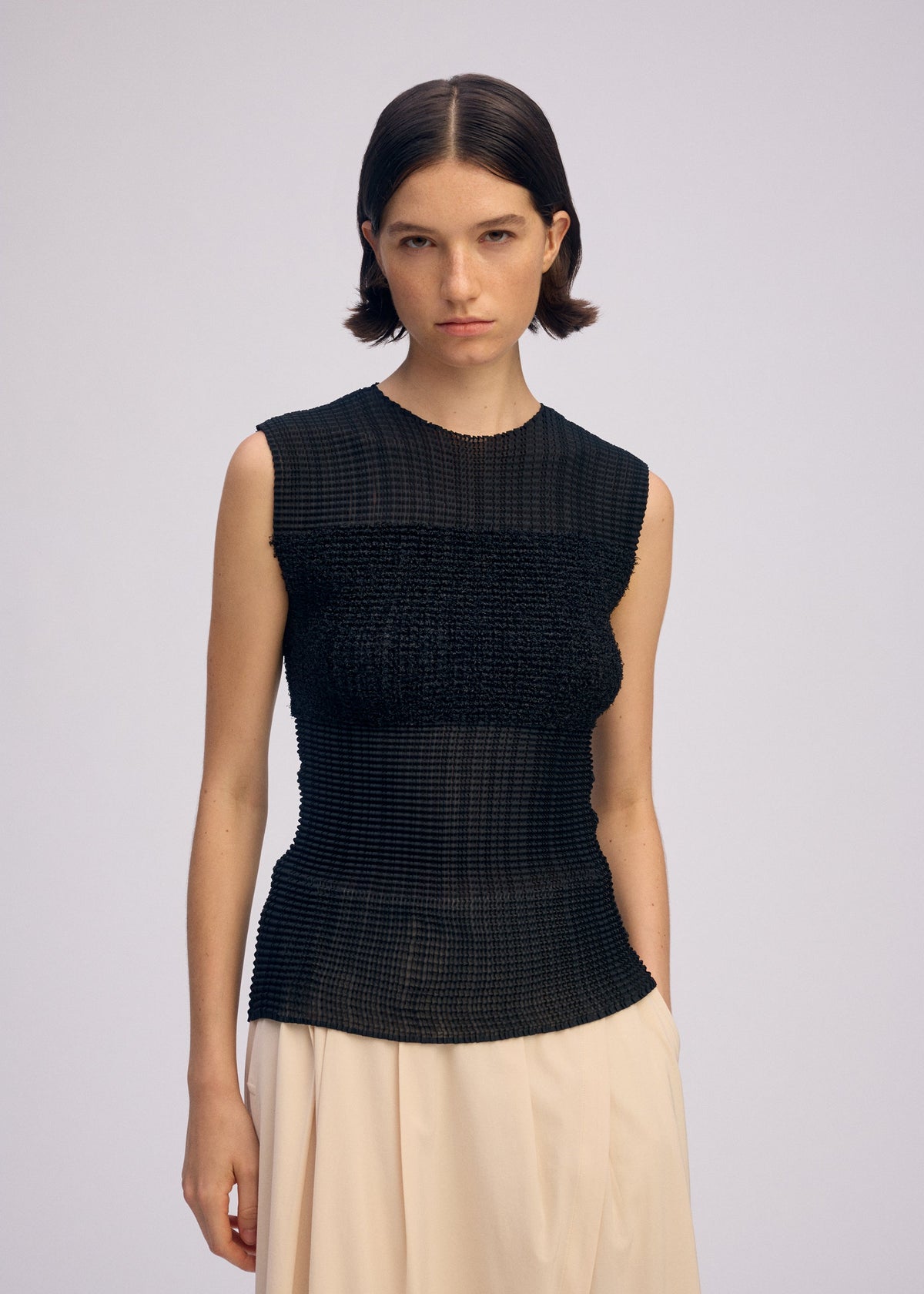 A model wears the ISSEY MIYAKE SHEER FUZZY PLEATS shirt.