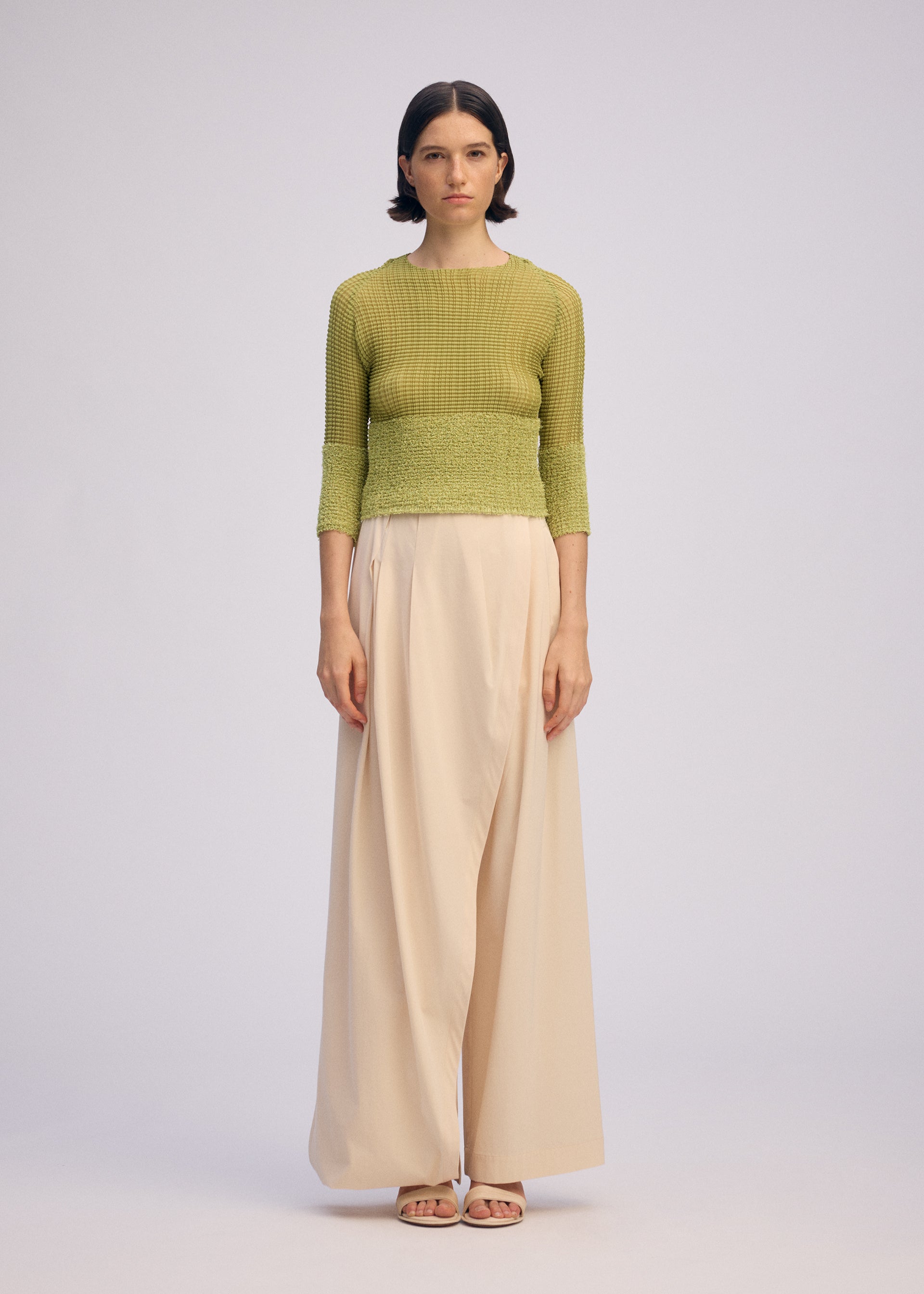 A model wears the ISSEY MIYAKE SHEER FUZZY PLEATS shirt.