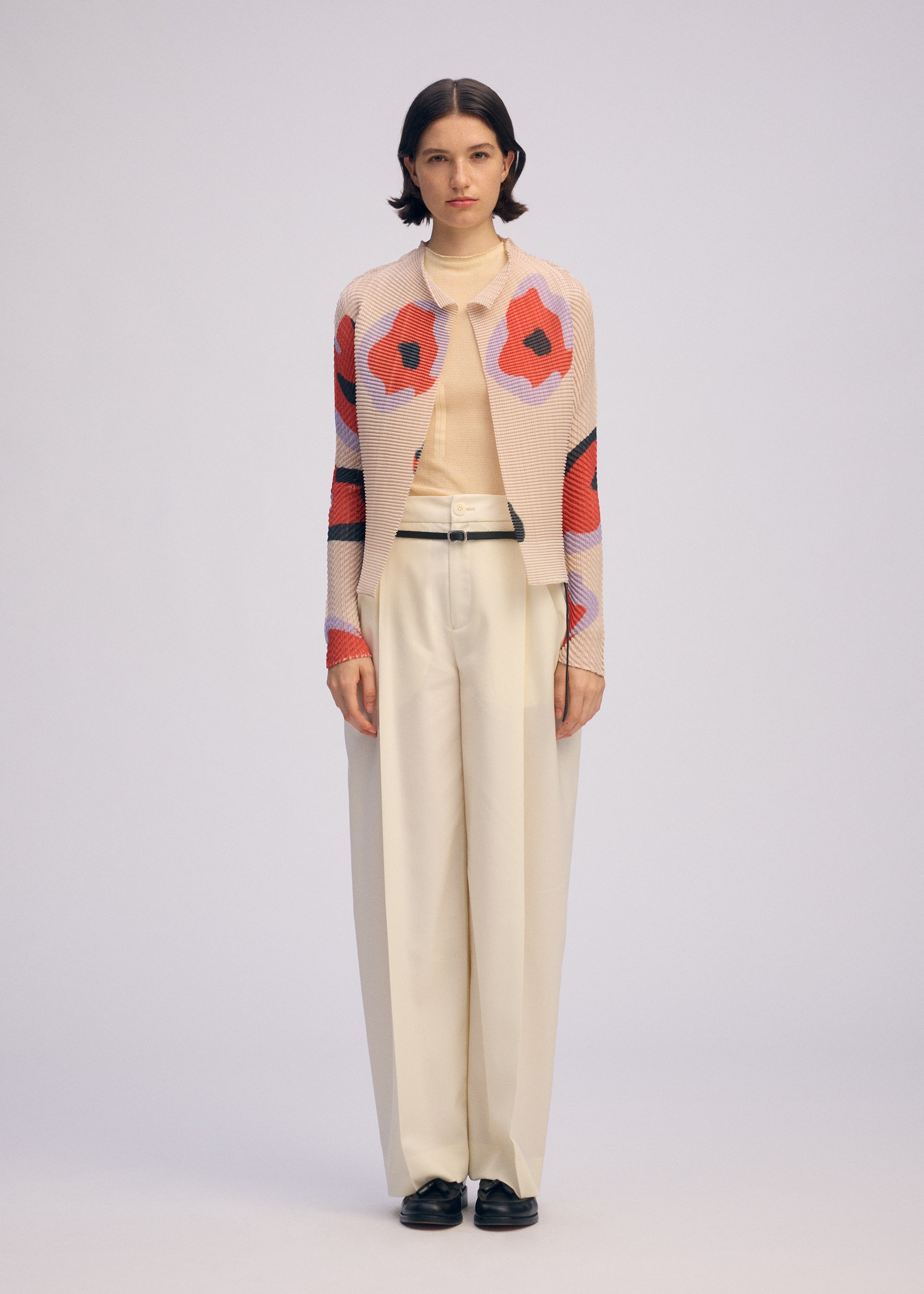 A model wears the ISSEY MIYAKE VERVE PLEATS TOP shirt.