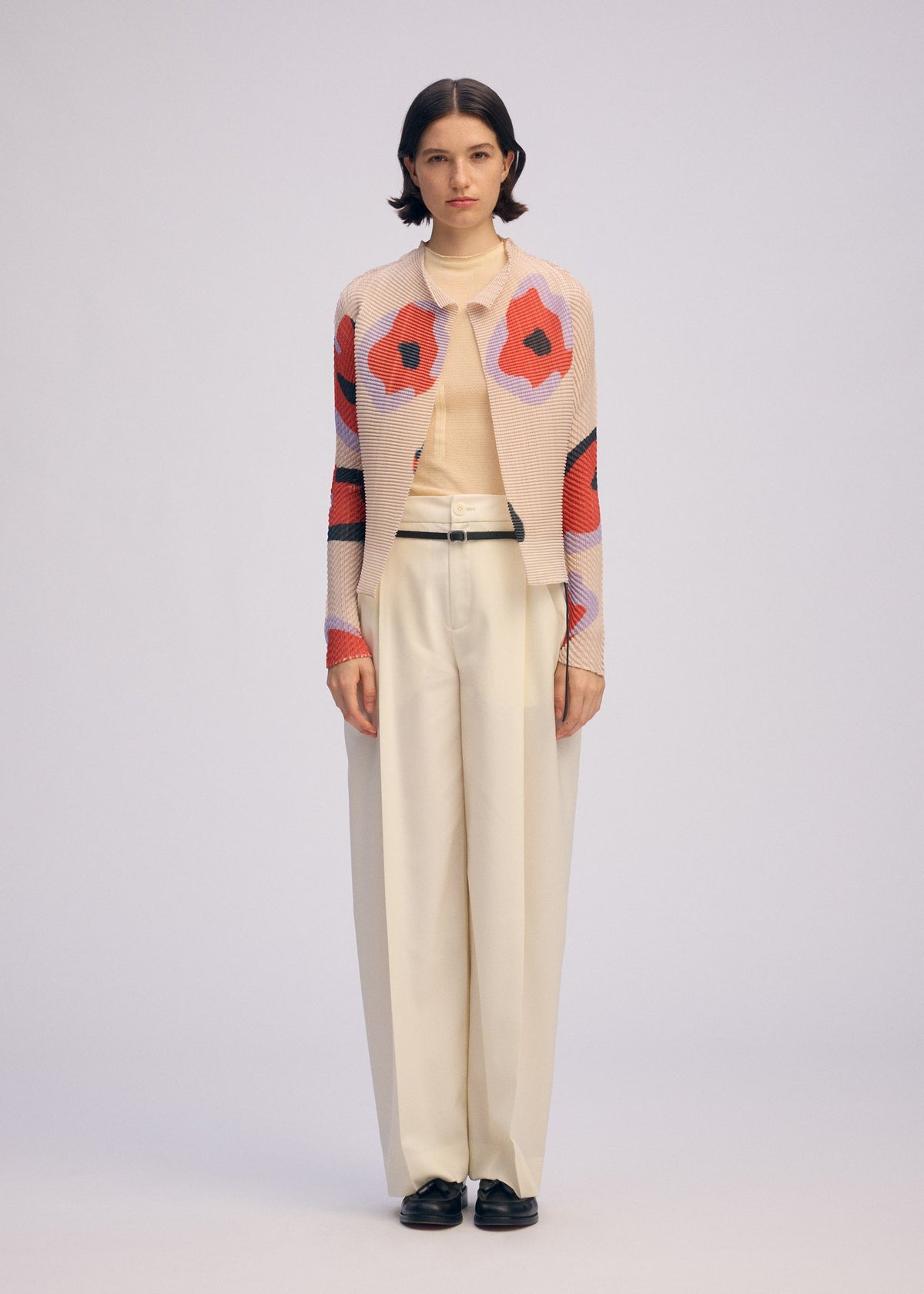 A model wears the ISSEY MIYAKE VERVE PLEATS TOP shirt.