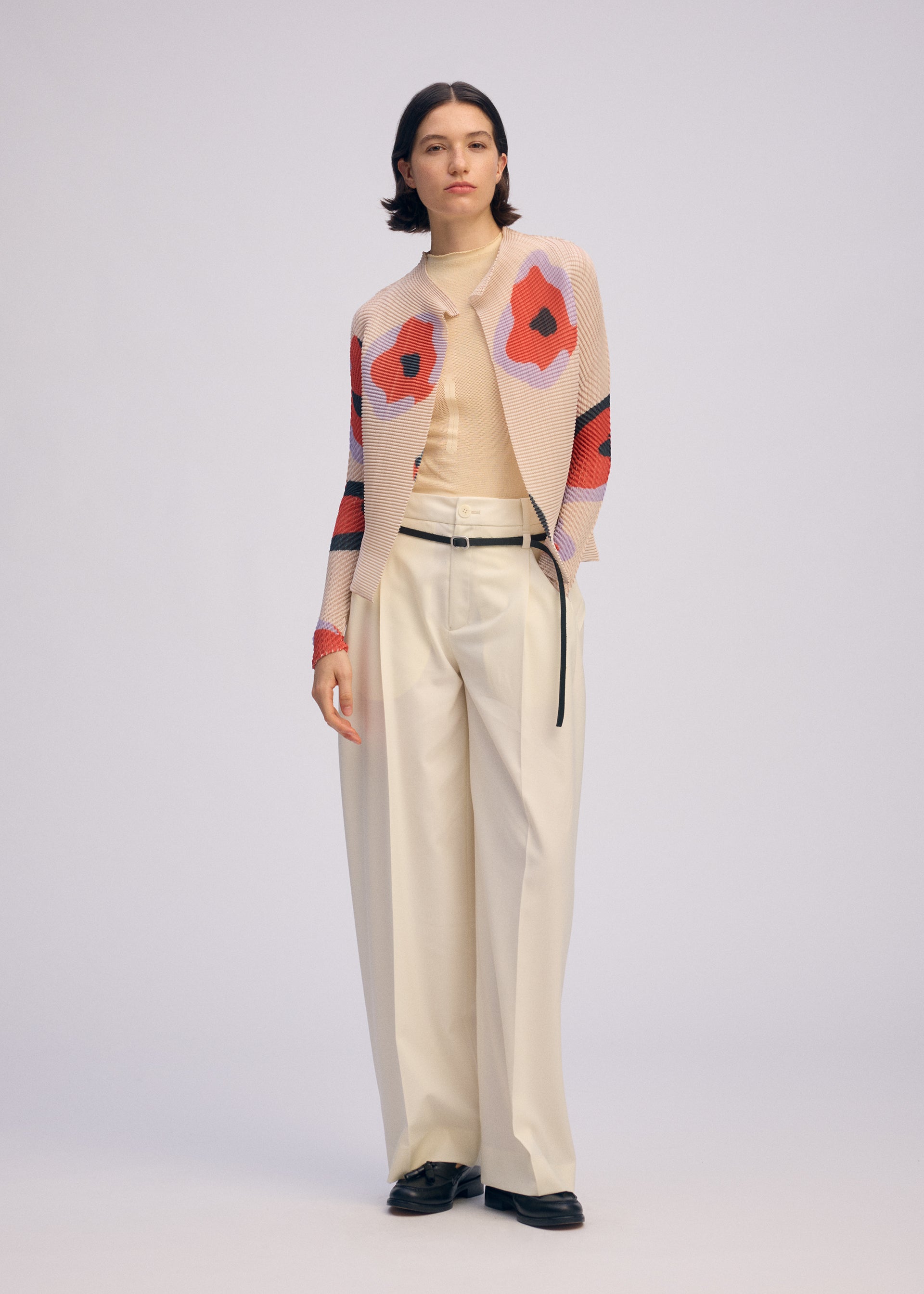 A model wears the ISSEY MIYAKE VERVE PLEATS TOP shirt.