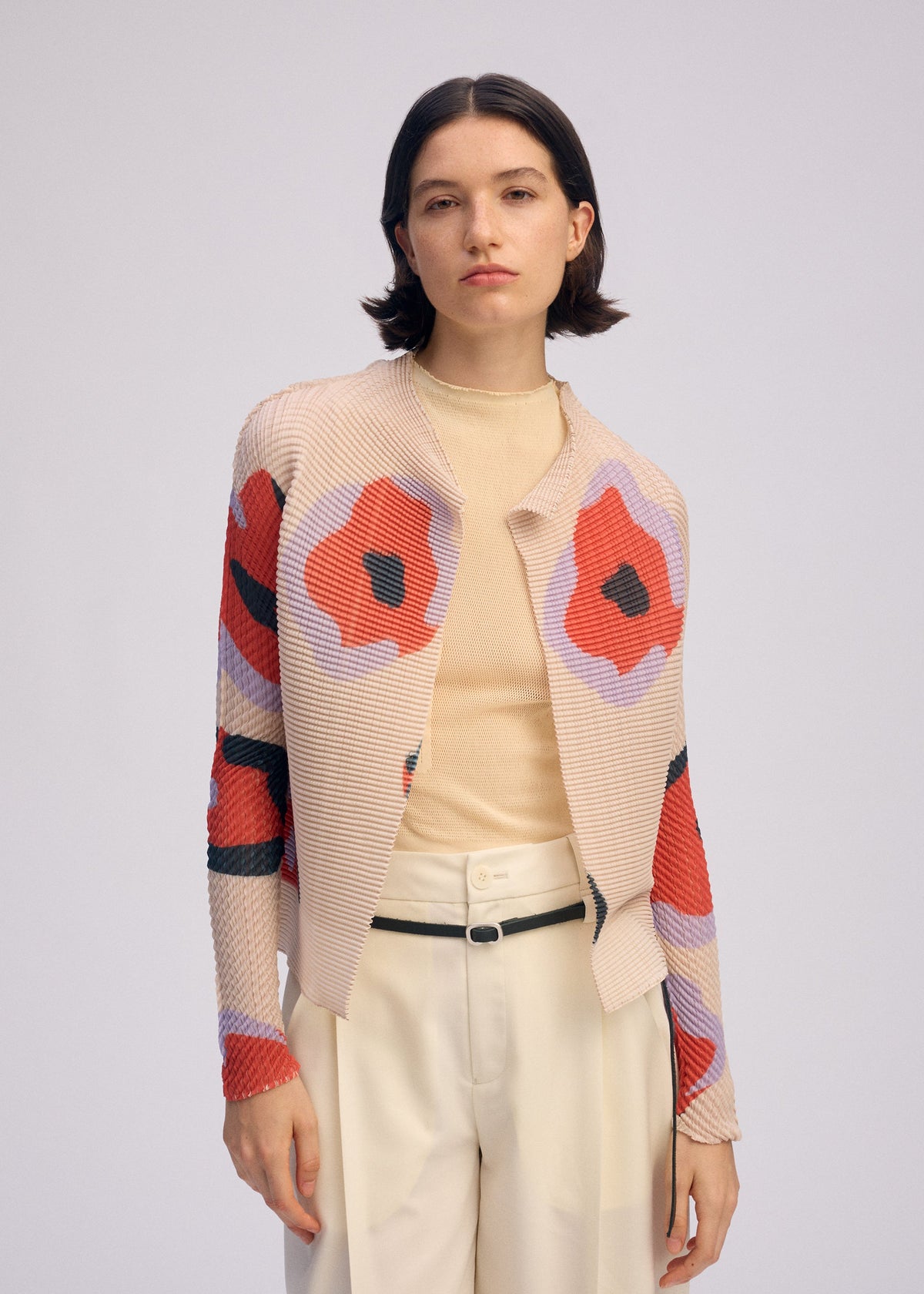 A model wears the ISSEY MIYAKE VERVE PLEATS TOP shirt.
