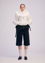 A model wears the ISSEY MIYAKE GENERIC WEAR cardigan.