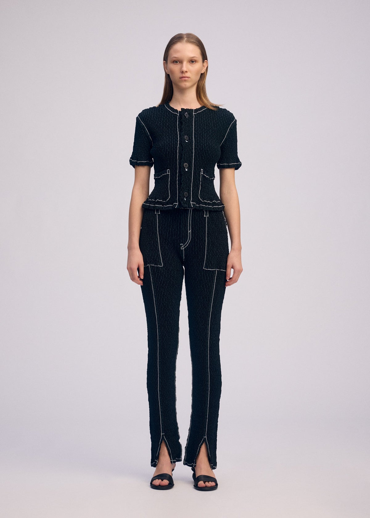 A model wears the ISSEY MIYAKE WAVELET ENSEMBLE cardigan.