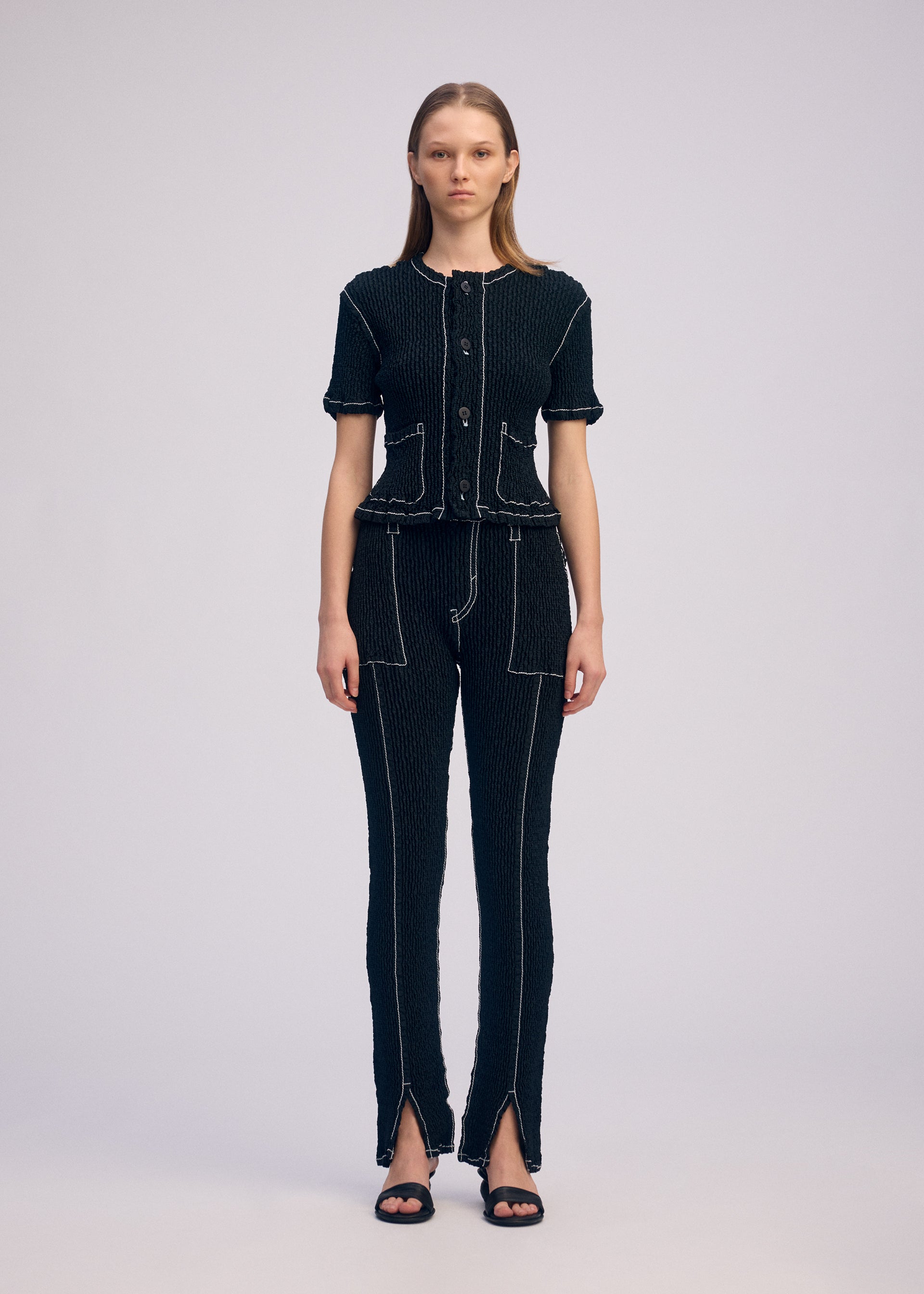 A model wears the ISSEY MIYAKE WAVELET ENSEMBLE cardigan.
