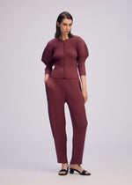 A model wears the ISSEY MIYAKE SLEEK PLEATS sleek-pleats-cardigan-burgundy.