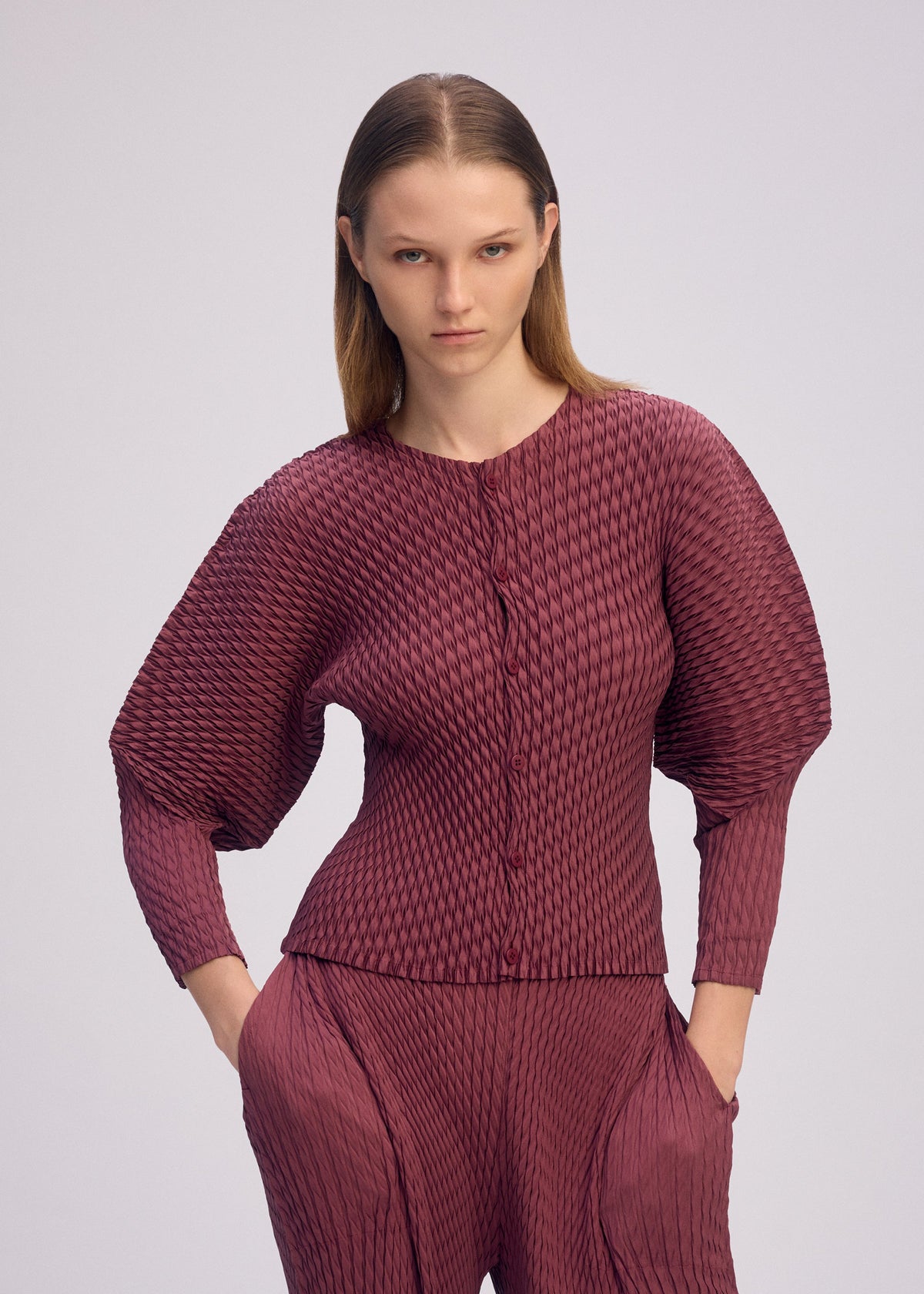 A model wears the ISSEY MIYAKE SLEEK PLEATS sleek-pleats-cardigan-black-1.