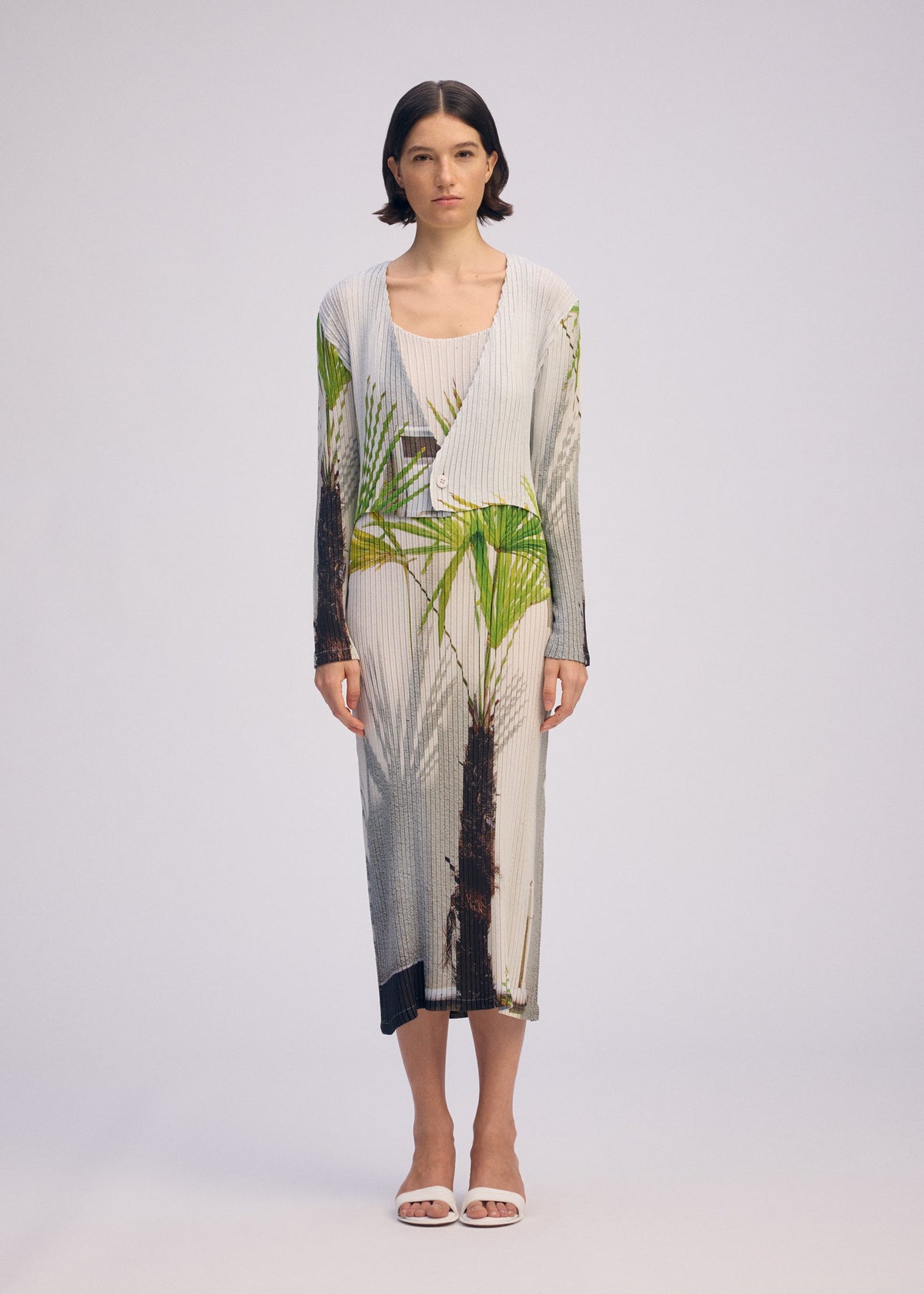 A model wears the ISSEY MIYAKE URBAN JUNGLE PLEATS cardigan.