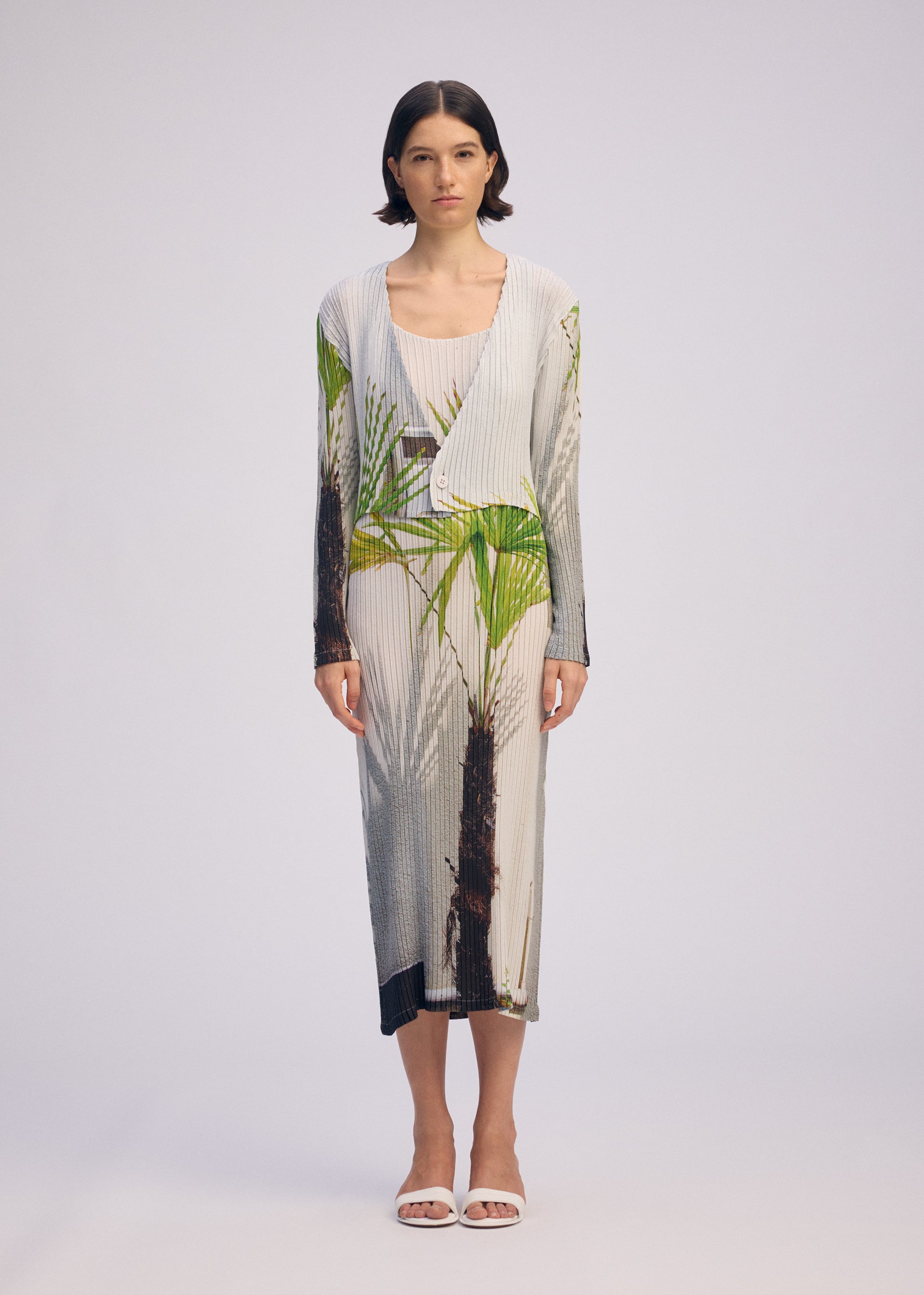 A model wears the ISSEY MIYAKE URBAN JUNGLE PLEATS cardigan.
