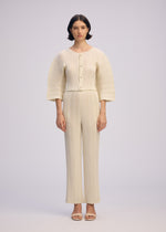 A model wears the ISSEY MIYAKE LINEN LIKE RIB PLEATS cardigan.