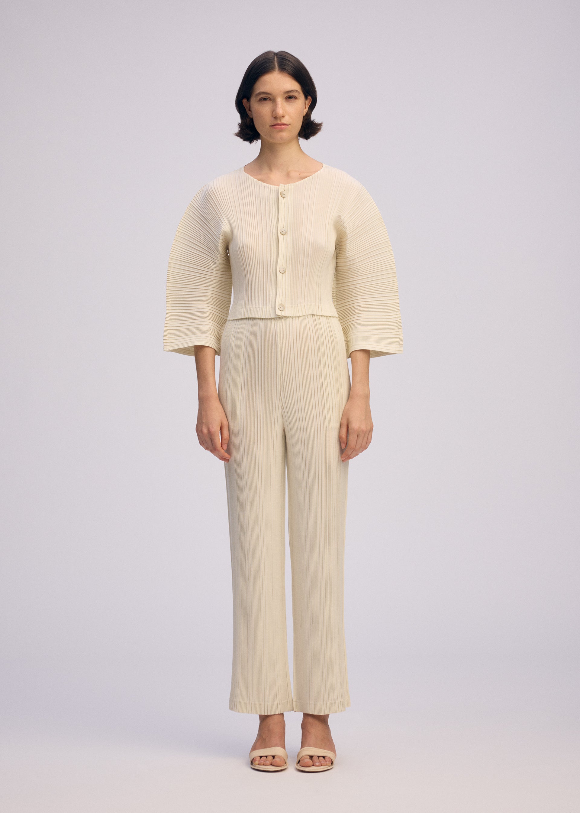 A model wears the ISSEY MIYAKE LINEN LIKE RIB PLEATS cardigan.