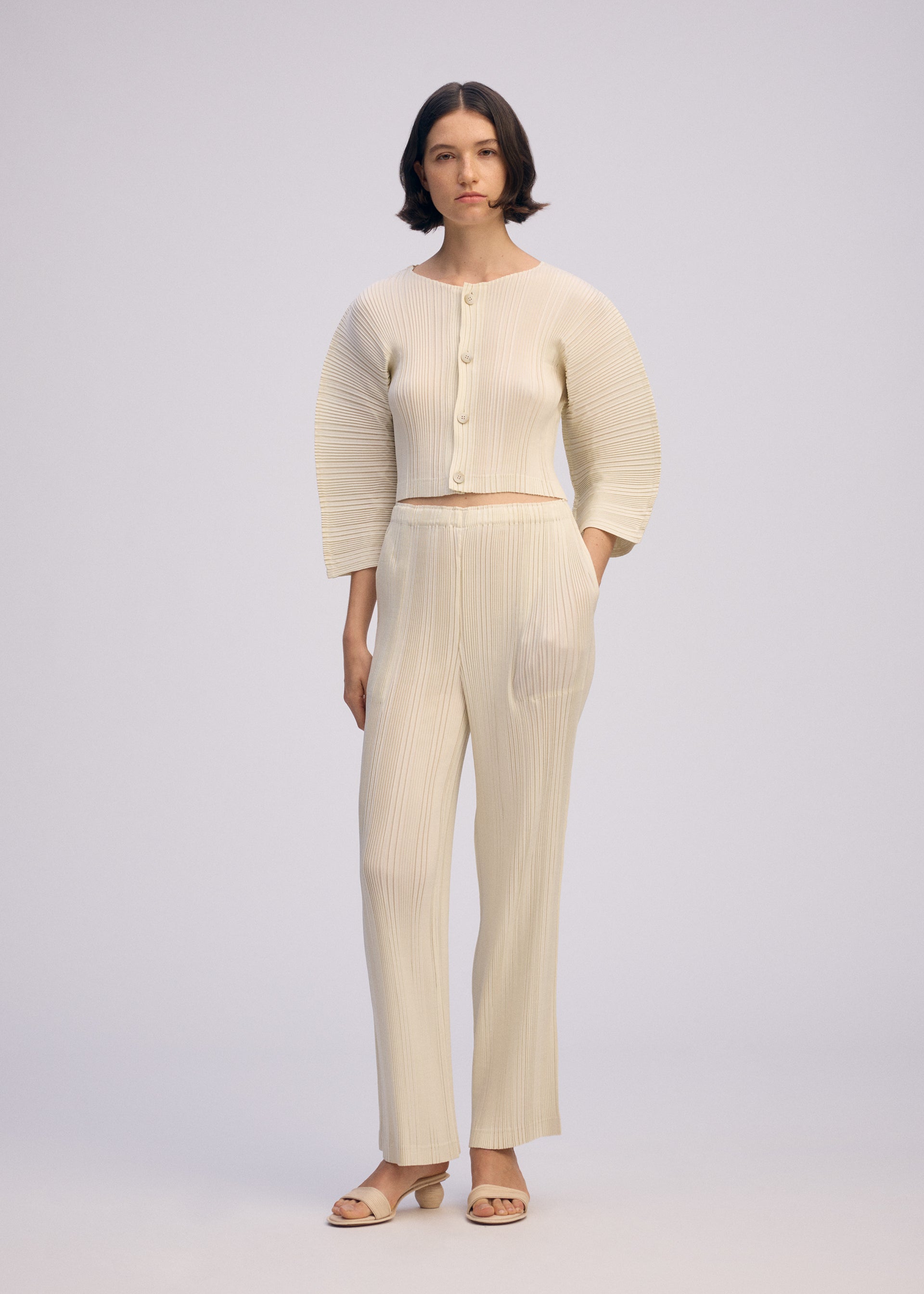 A model wears the ISSEY MIYAKE LINEN LIKE RIB PLEATS cardigan.