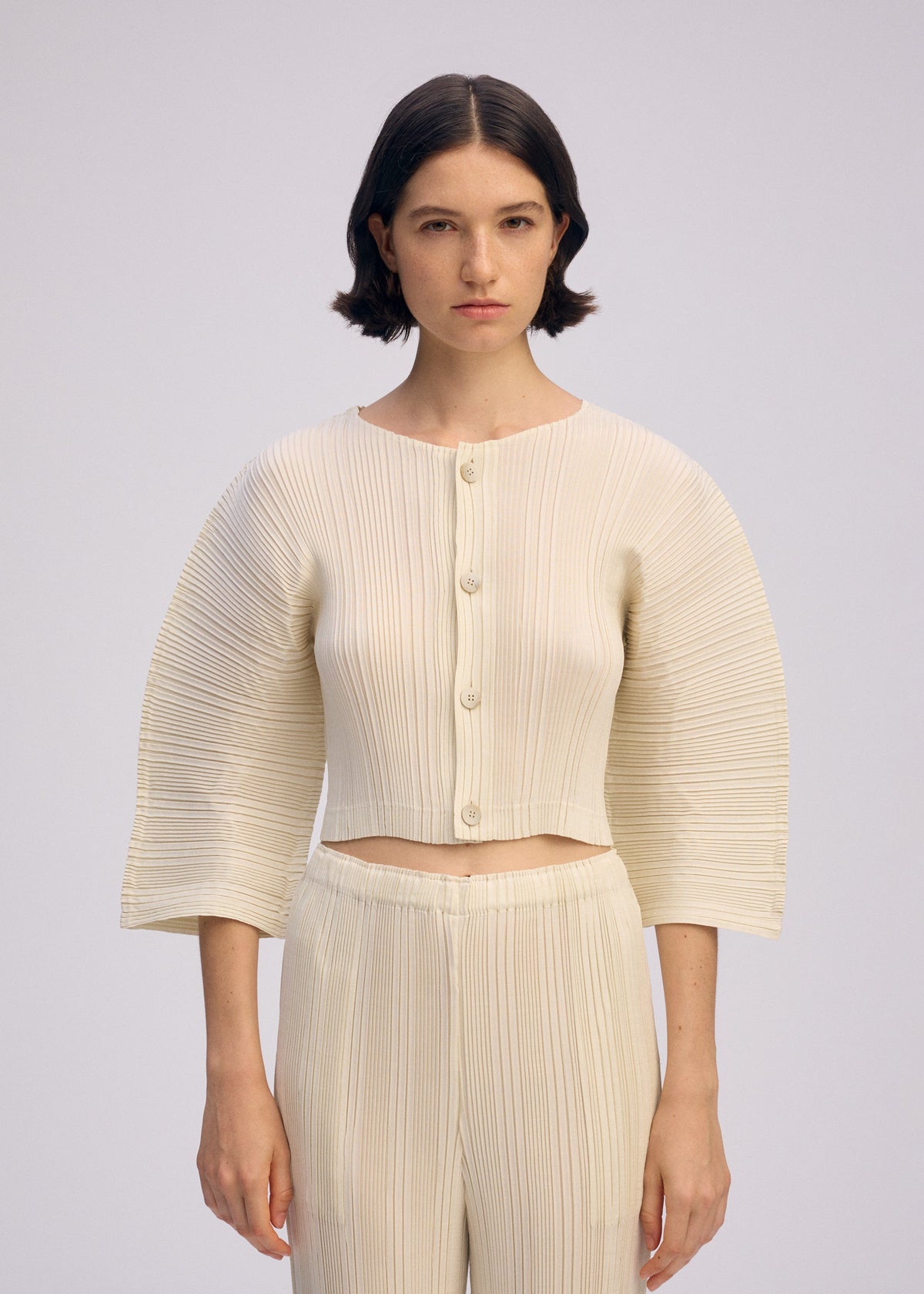 A model wears the ISSEY MIYAKE LINEN LIKE RIB PLEATS cardigan.