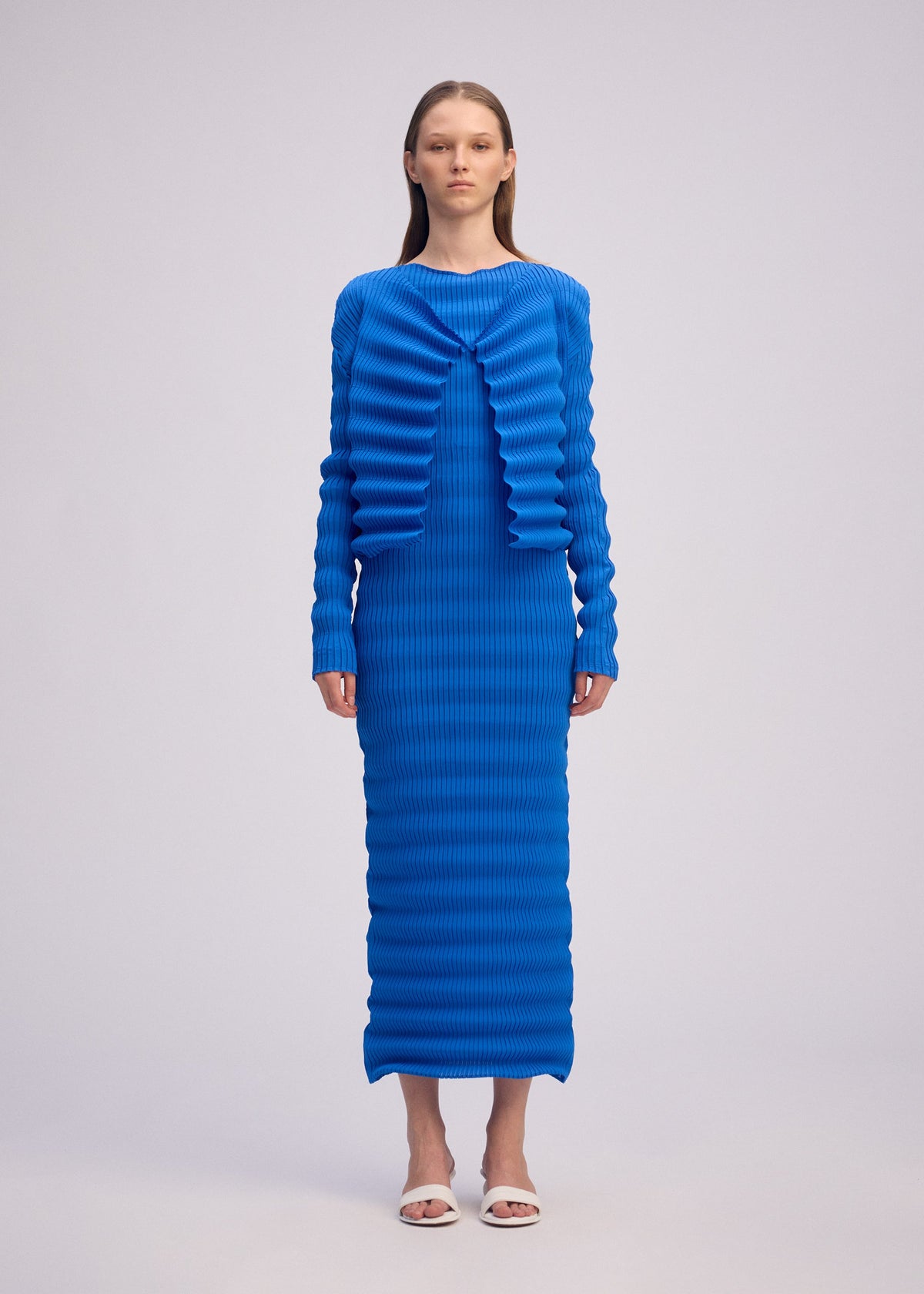 A model wears the ISSEY MIYAKE SPRING PLEATS spring-pleats-cardigan-black.