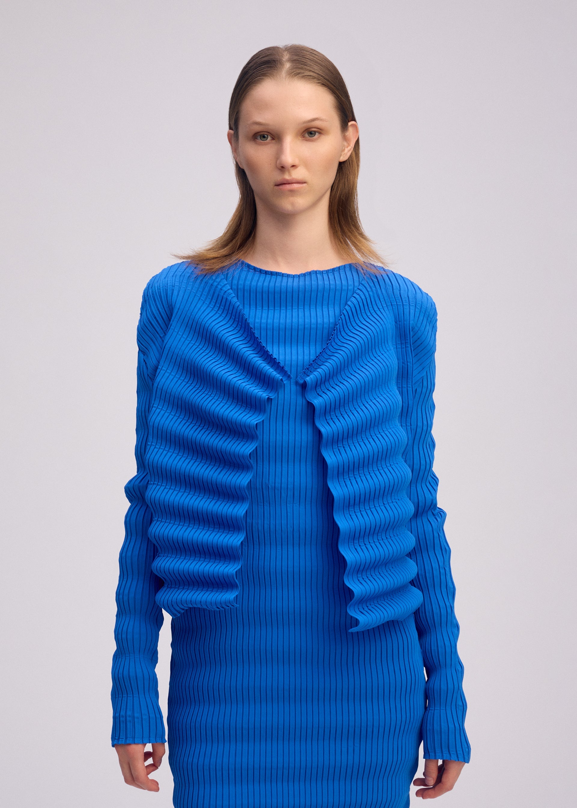 A model wears the ISSEY MIYAKE SPRING PLEATS spring-pleats-cardigan-starling-blue.