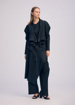 A model wears the ISSEY MIYAKE PLEATED ON PLEATS cardigan.