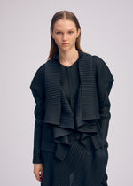 A model wears the ISSEY MIYAKE PLEATED ON PLEATS cardigan.