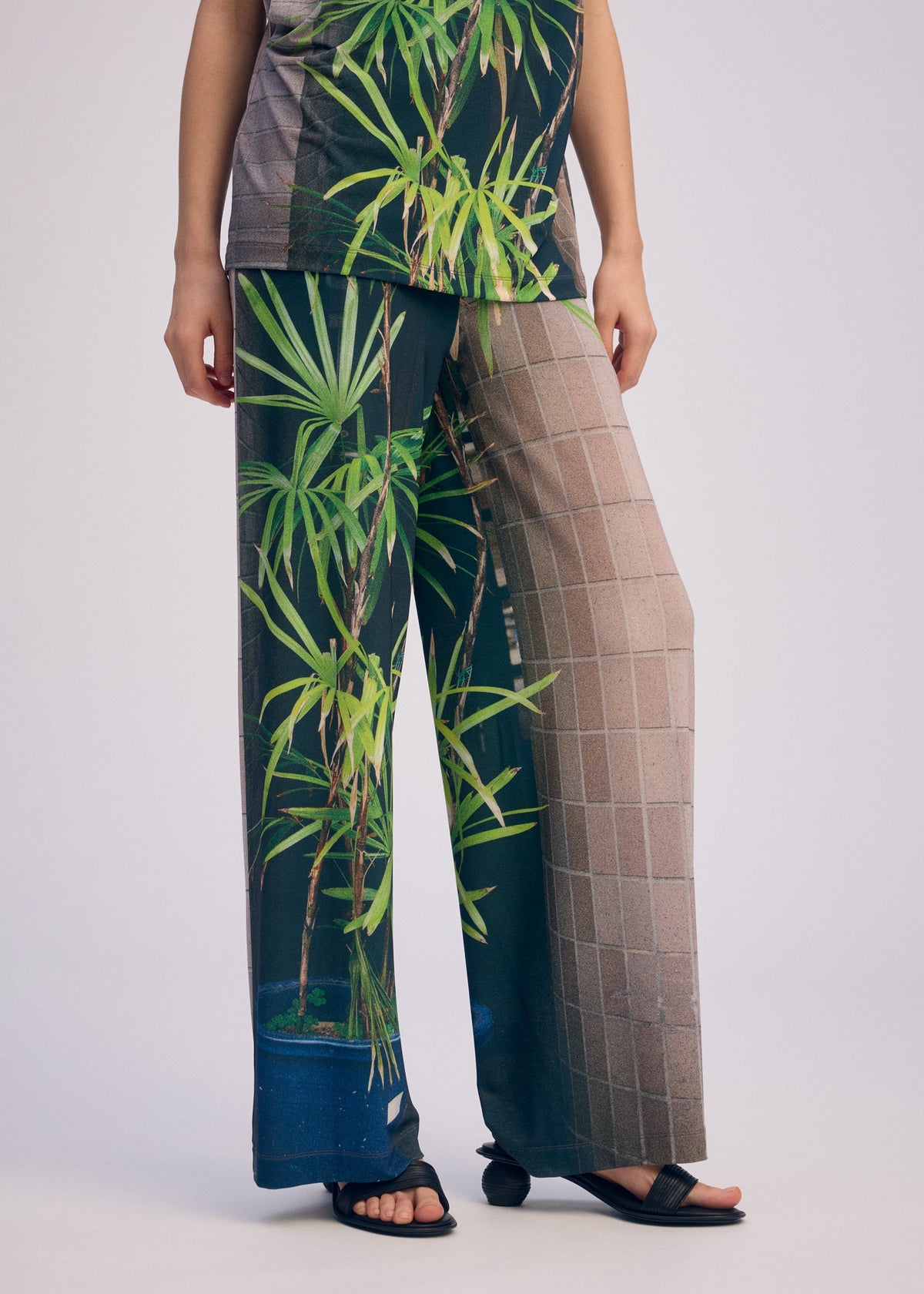 A model wears the ISSEY MIYAKE URBAN JUNGLE JERSEY trousers.