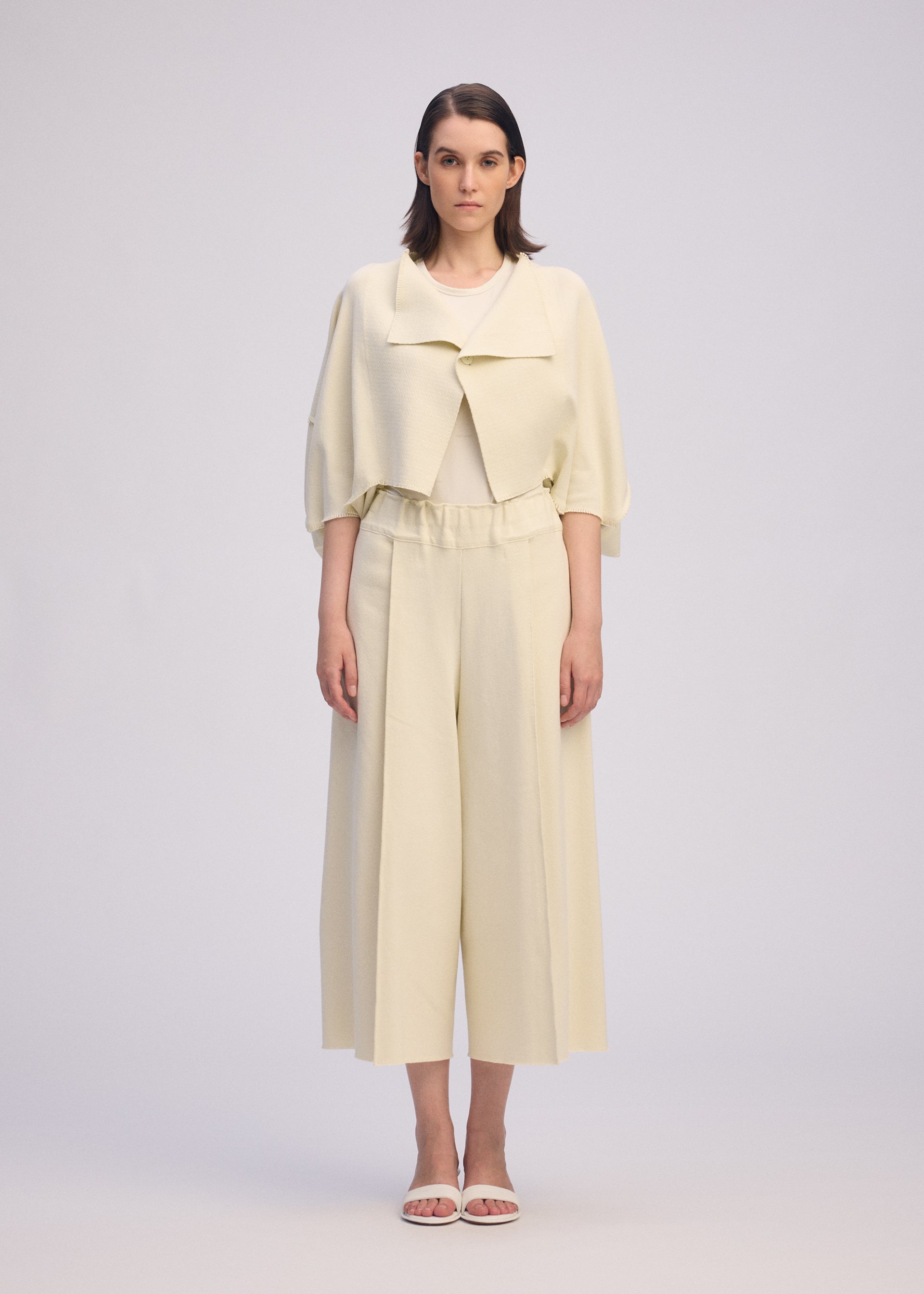 A model wears the ISSEY MIYAKE CAMPAGNE trousers.