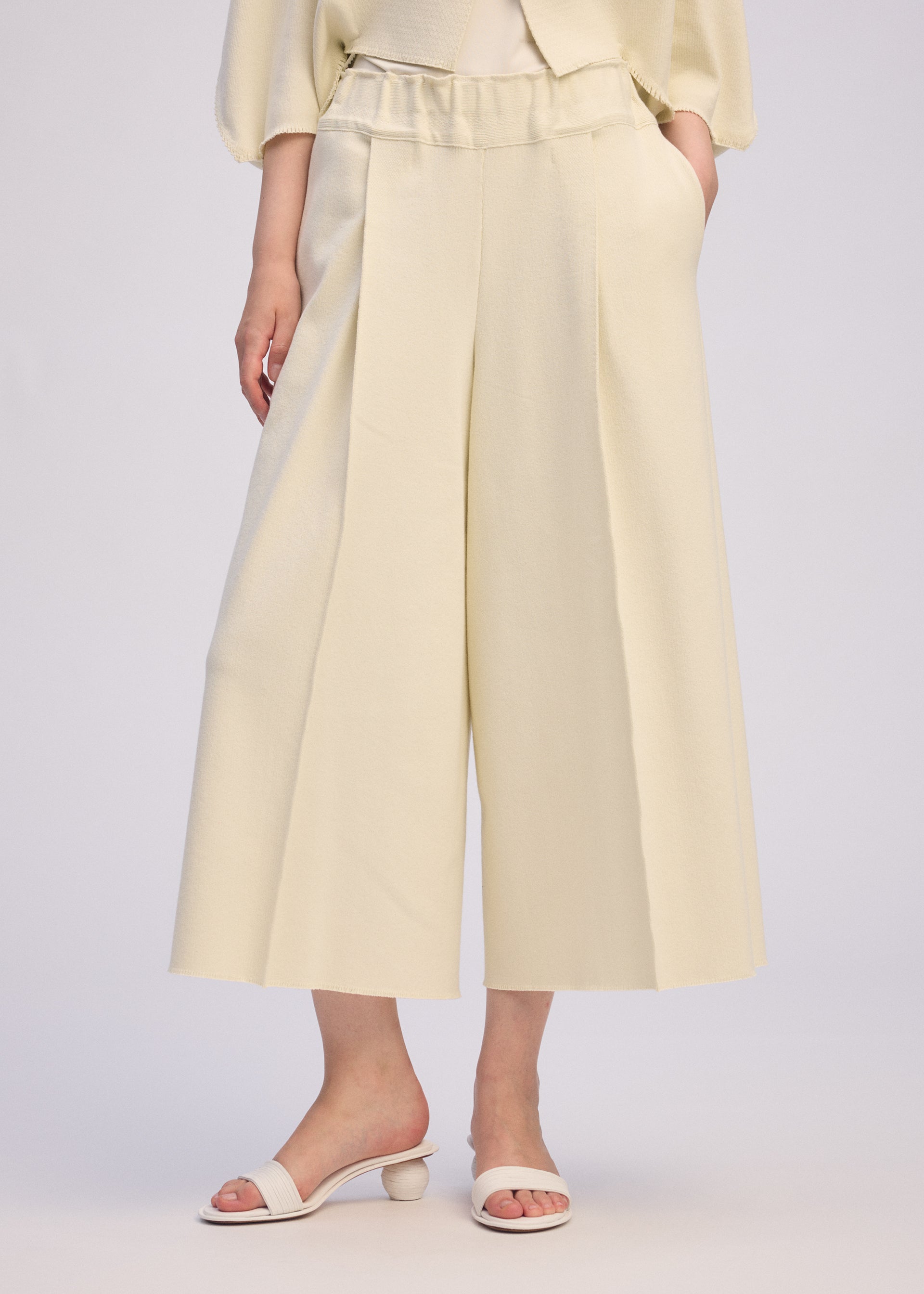 A model wears the ISSEY MIYAKE CAMPAGNE trousers.