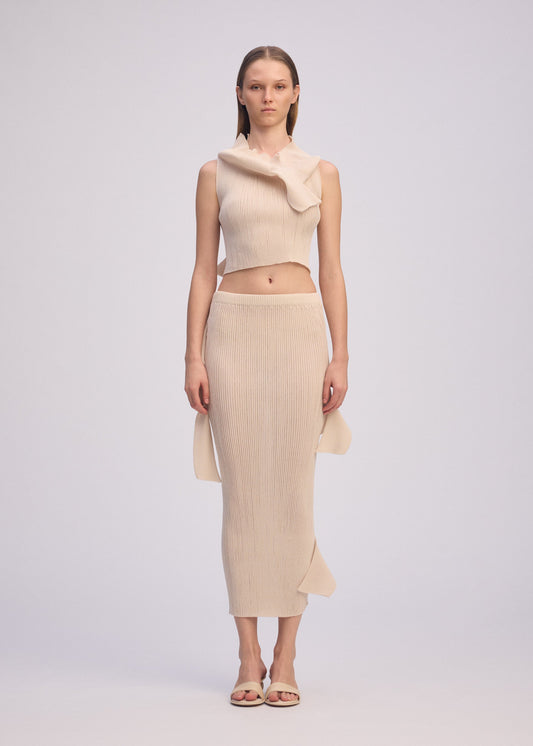 A model wears the ISSEY MIYAKE ADVENTITIOUS HIGH NECKS skirt.