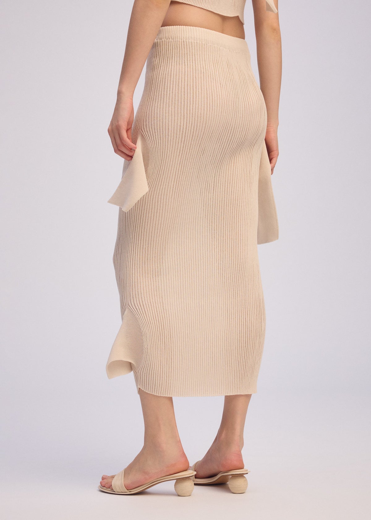 A model wears the ISSEY MIYAKE ADVENTITIOUS HIGH NECKS skirt.