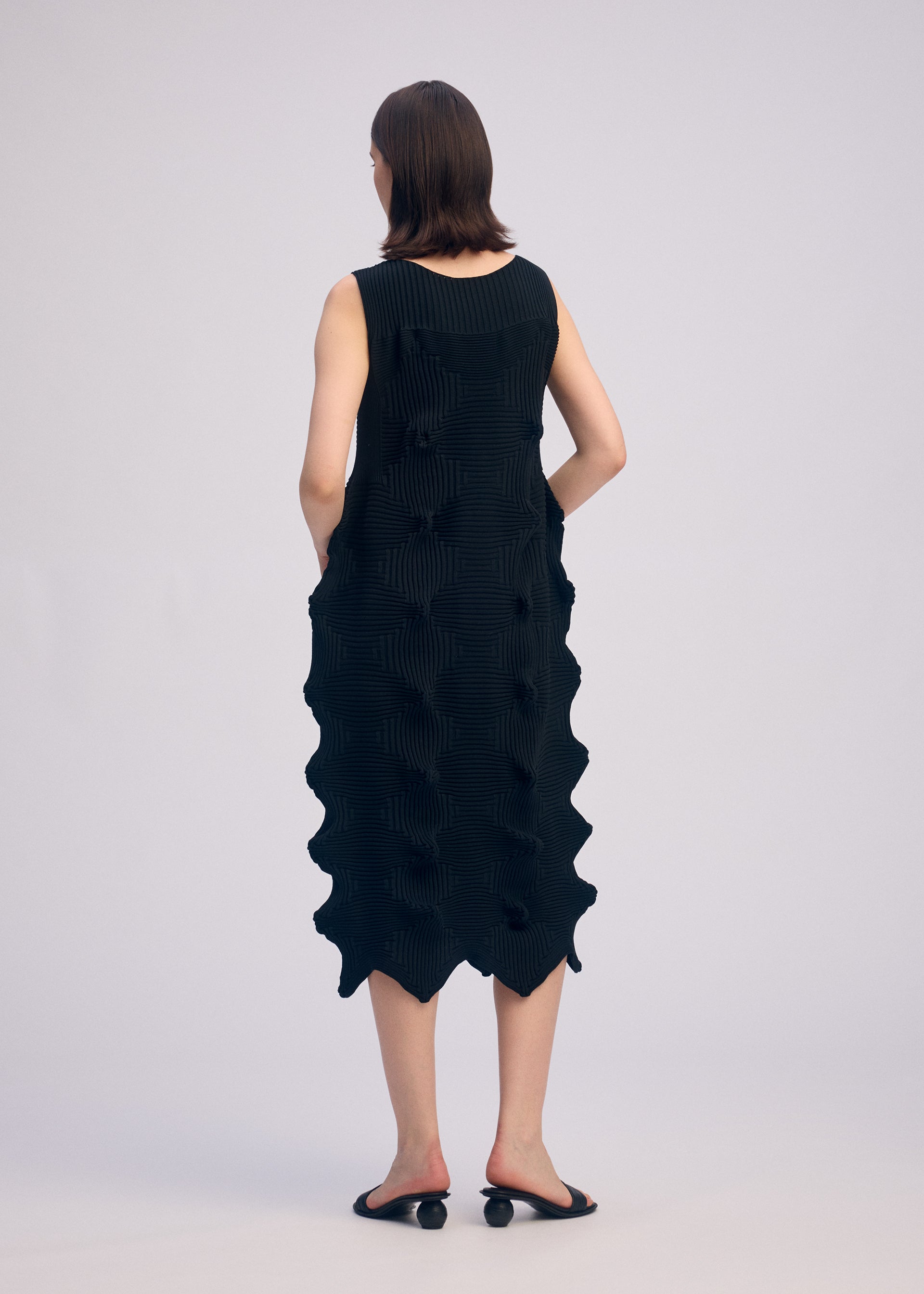 A model wears the ISSEY MIYAKE LINKAGE dress.