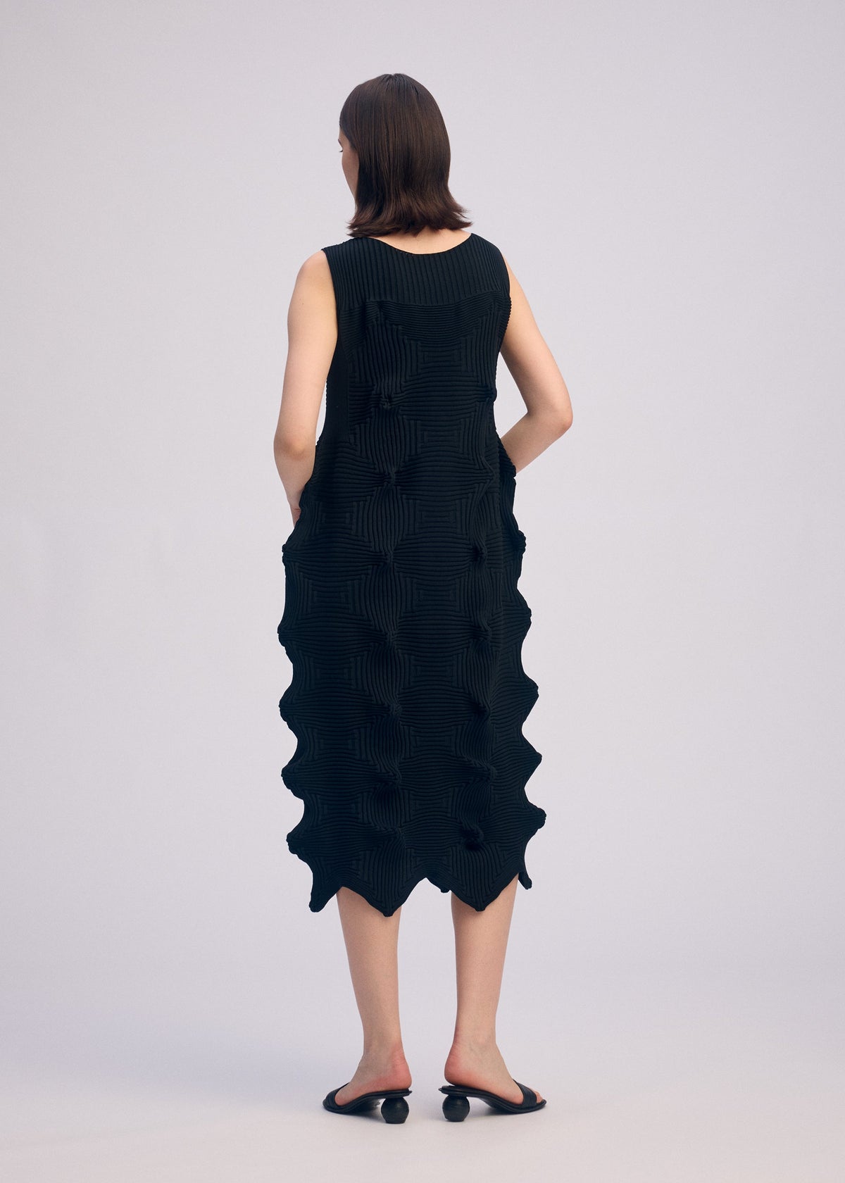 A model wears the ISSEY MIYAKE LINKAGE dress.