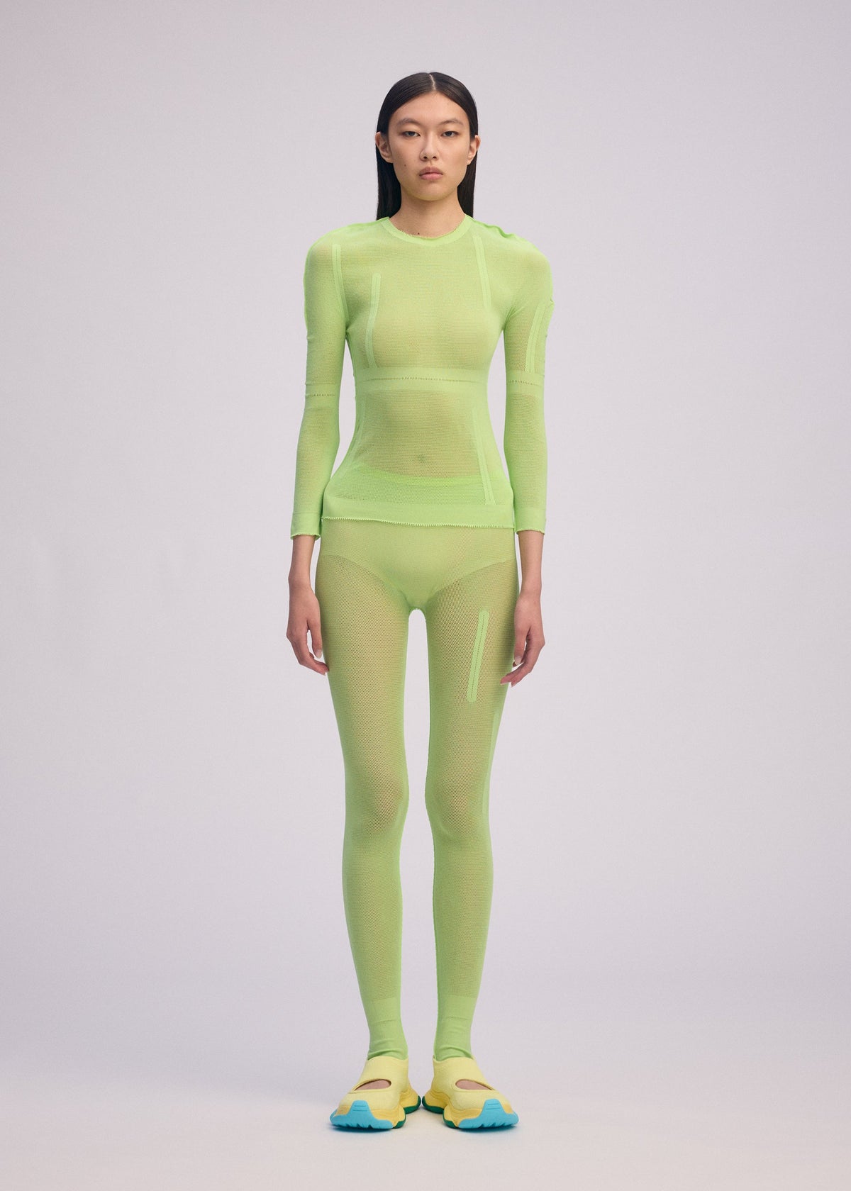 A model wears the ISSEY MIYAKE SLITS MESH AP top.
