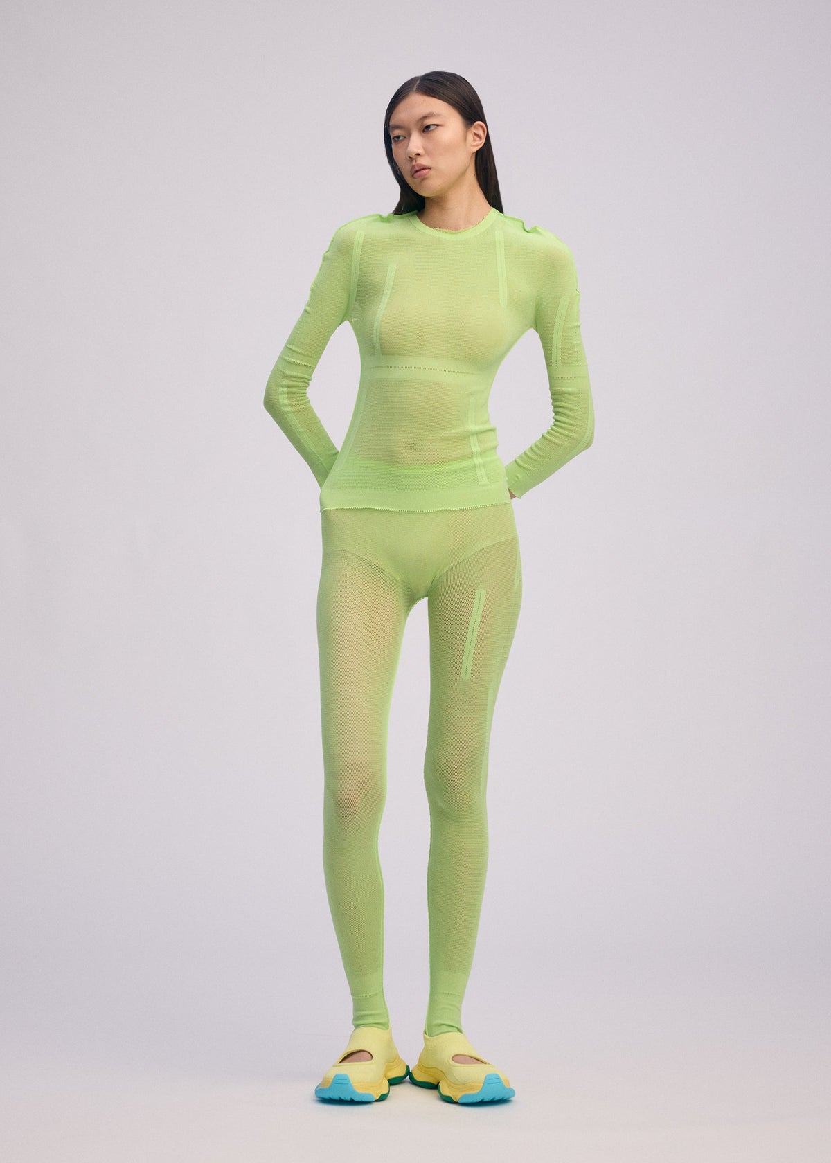 A model wears the ISSEY MIYAKE SLITS MESH AP top.