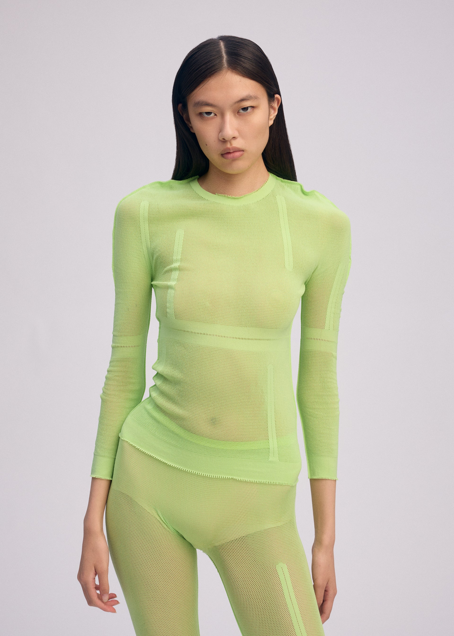 A model wears the ISSEY MIYAKE SLITS MESH AP top.