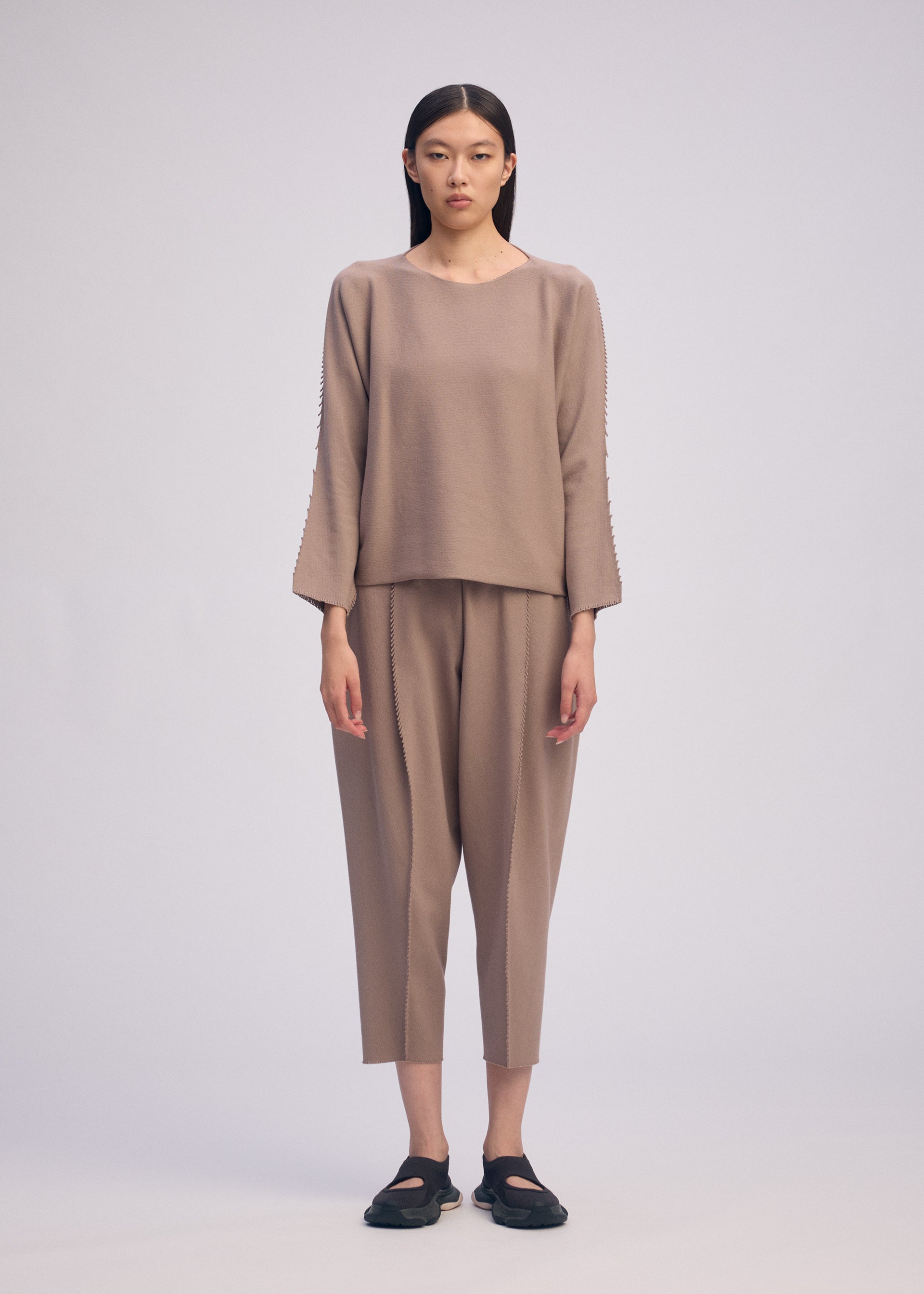 A model wears the ISSEY MIYAKE CAMPAGNE top.