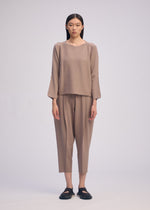 A model wears the ISSEY MIYAKE CAMPAGNE top.