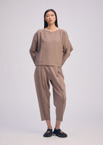 A model wears the ISSEY MIYAKE CAMPAGNE top.