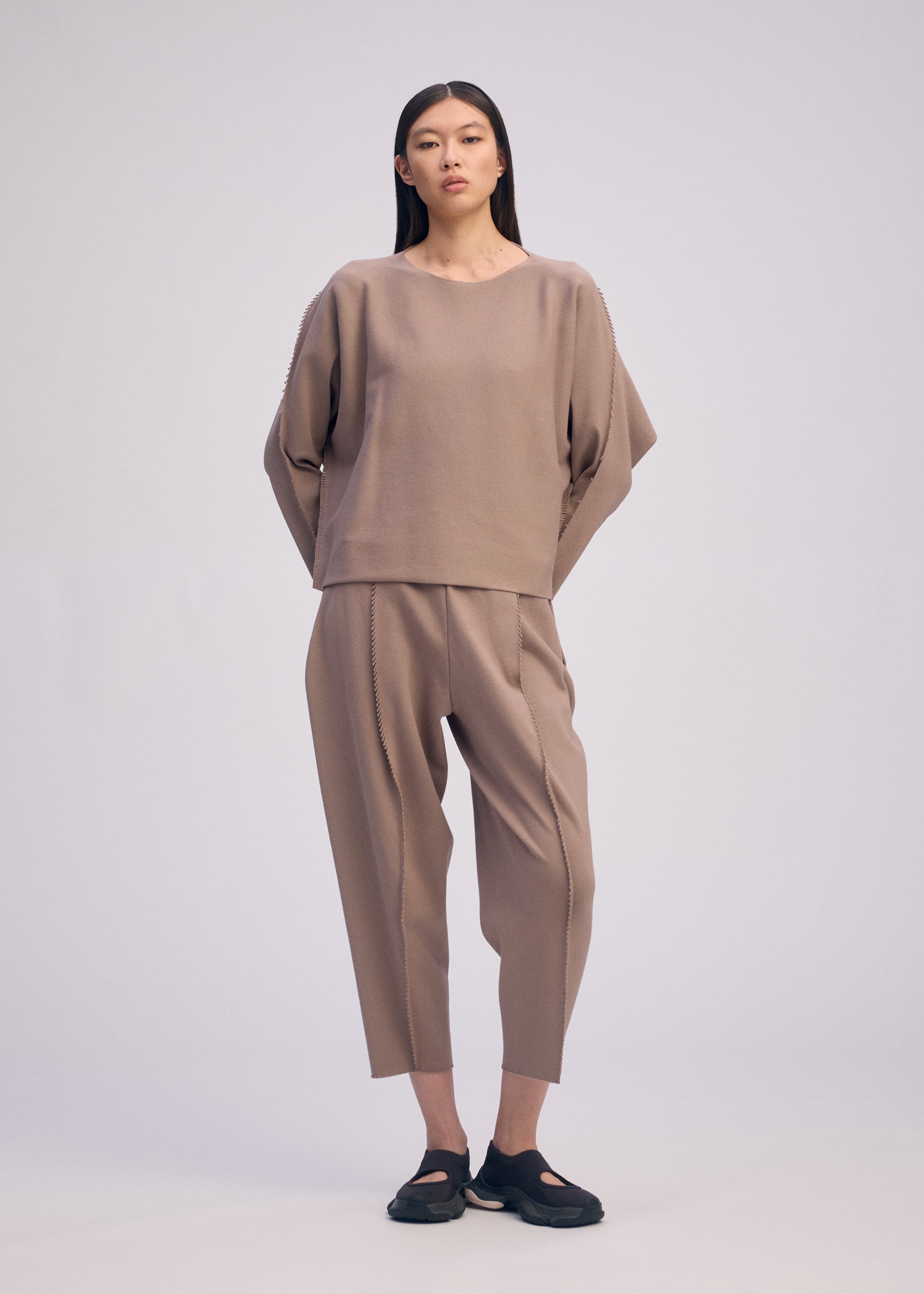 A model wears the ISSEY MIYAKE CAMPAGNE top.