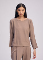 A model wears the ISSEY MIYAKE CAMPAGNE top.